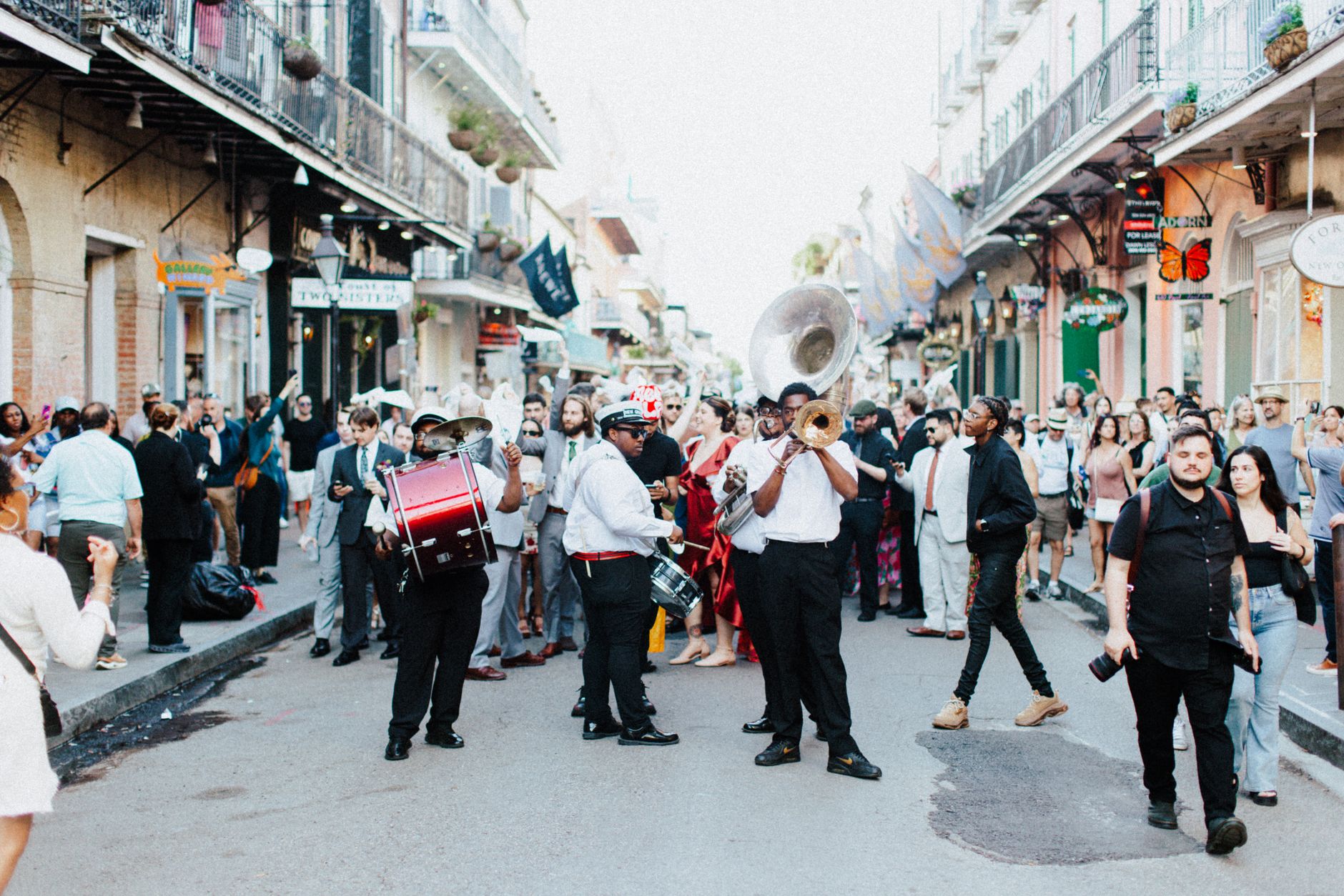 A lively street parade with musicians and crowds in the heart of New Orleans.