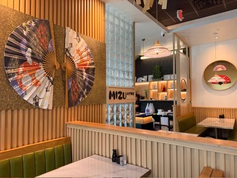 Mizu Sushi dining room with large decorative Japanese fans and green booth seating