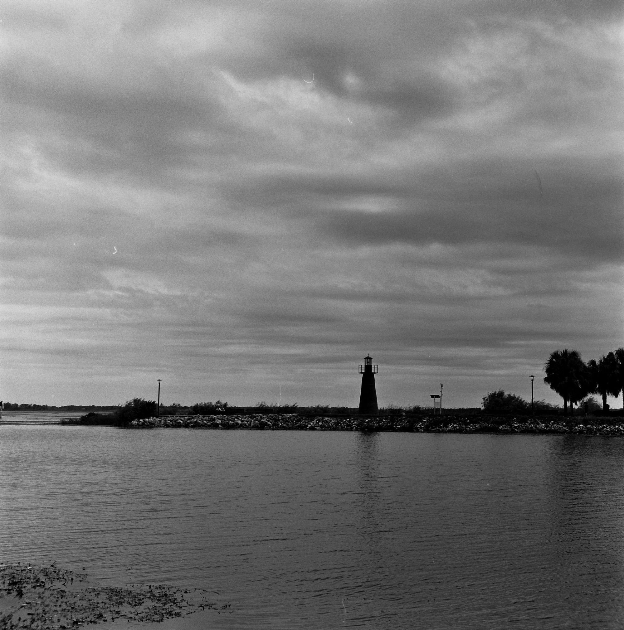 Black and white photograph of a lighthouse beside a lakeshore on Lake Toho, Florida