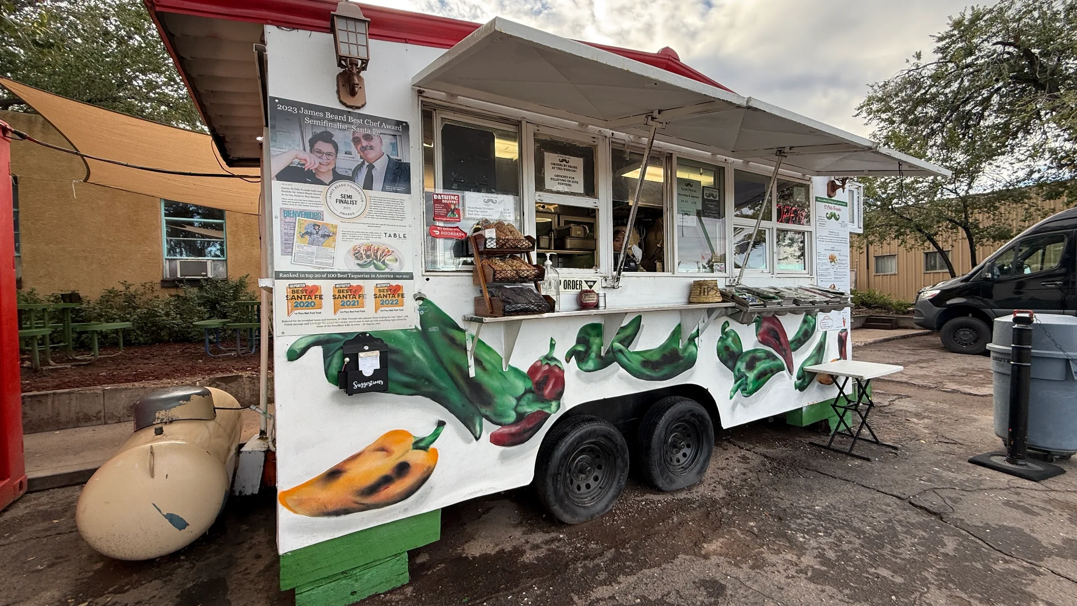 Red shipping container with El Chile Toreado signage reading Voted One of the 100 Best Taquerias in America, Yelp 2022
