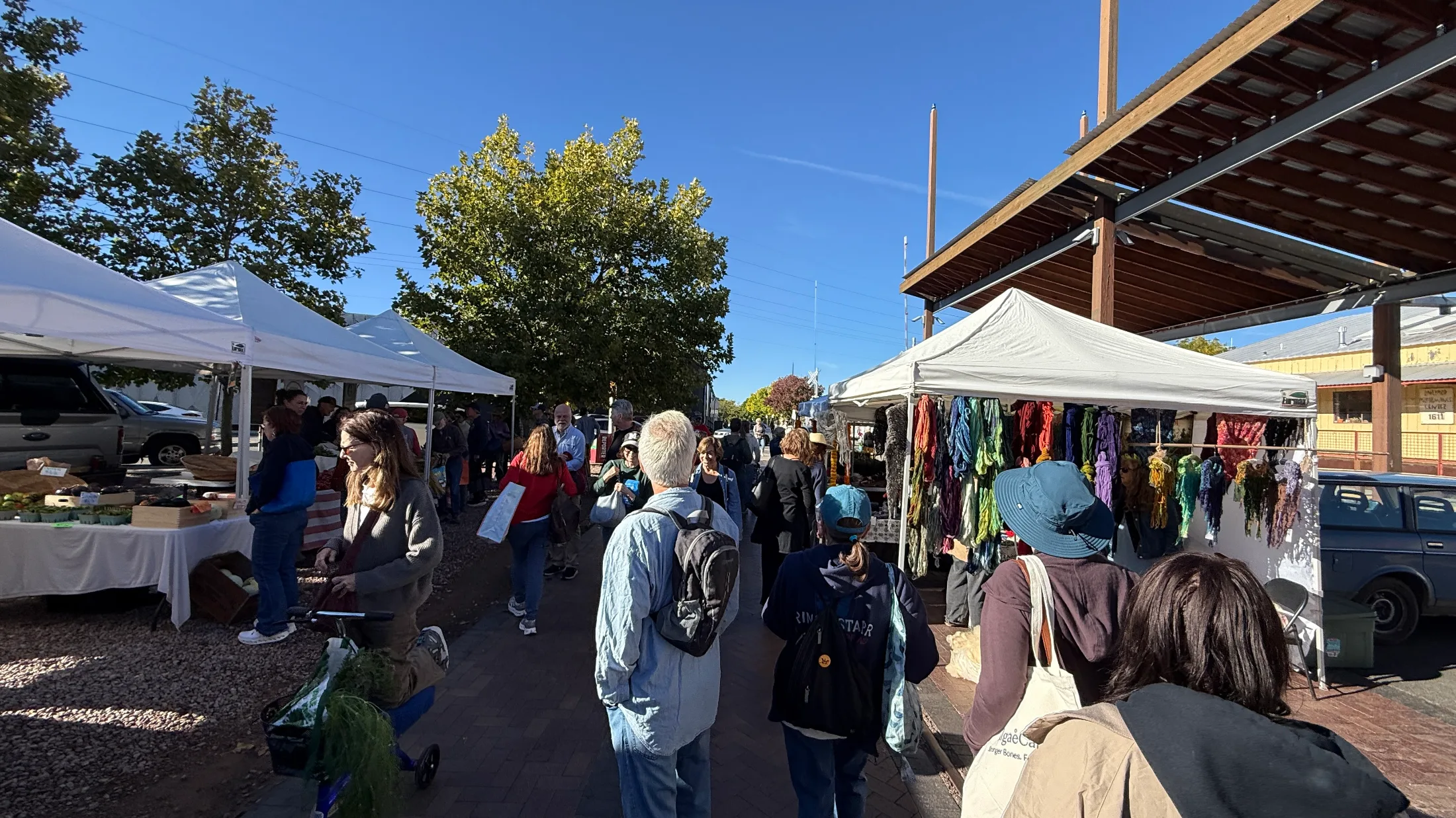 Shoppers browsing vendor tents along the outdoor market aisles at the Santa Fe Railyard