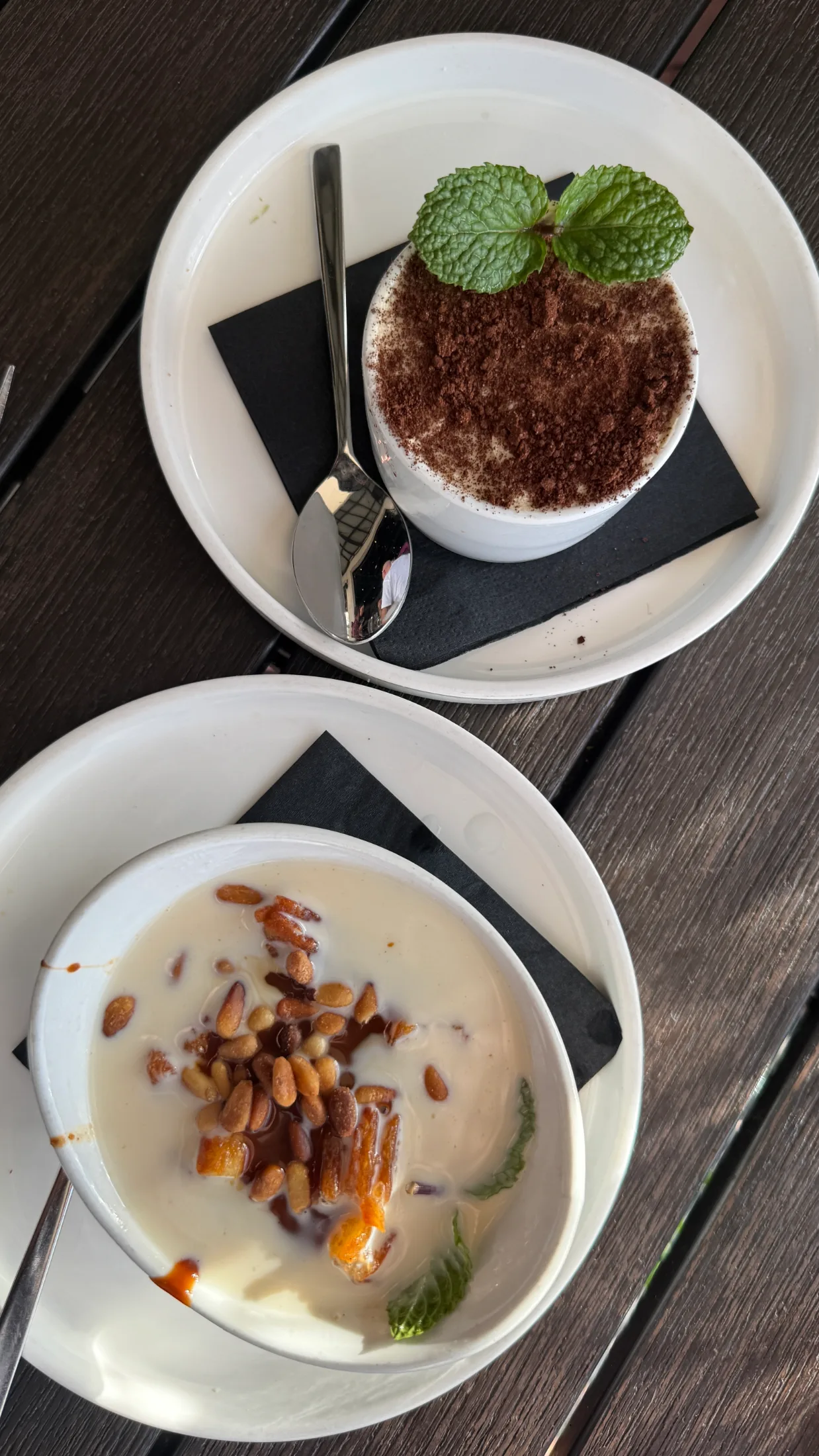 Two desserts at Escondido — a cocoa-dusted cup with mint, and a cream bowl with pine nuts and caramel