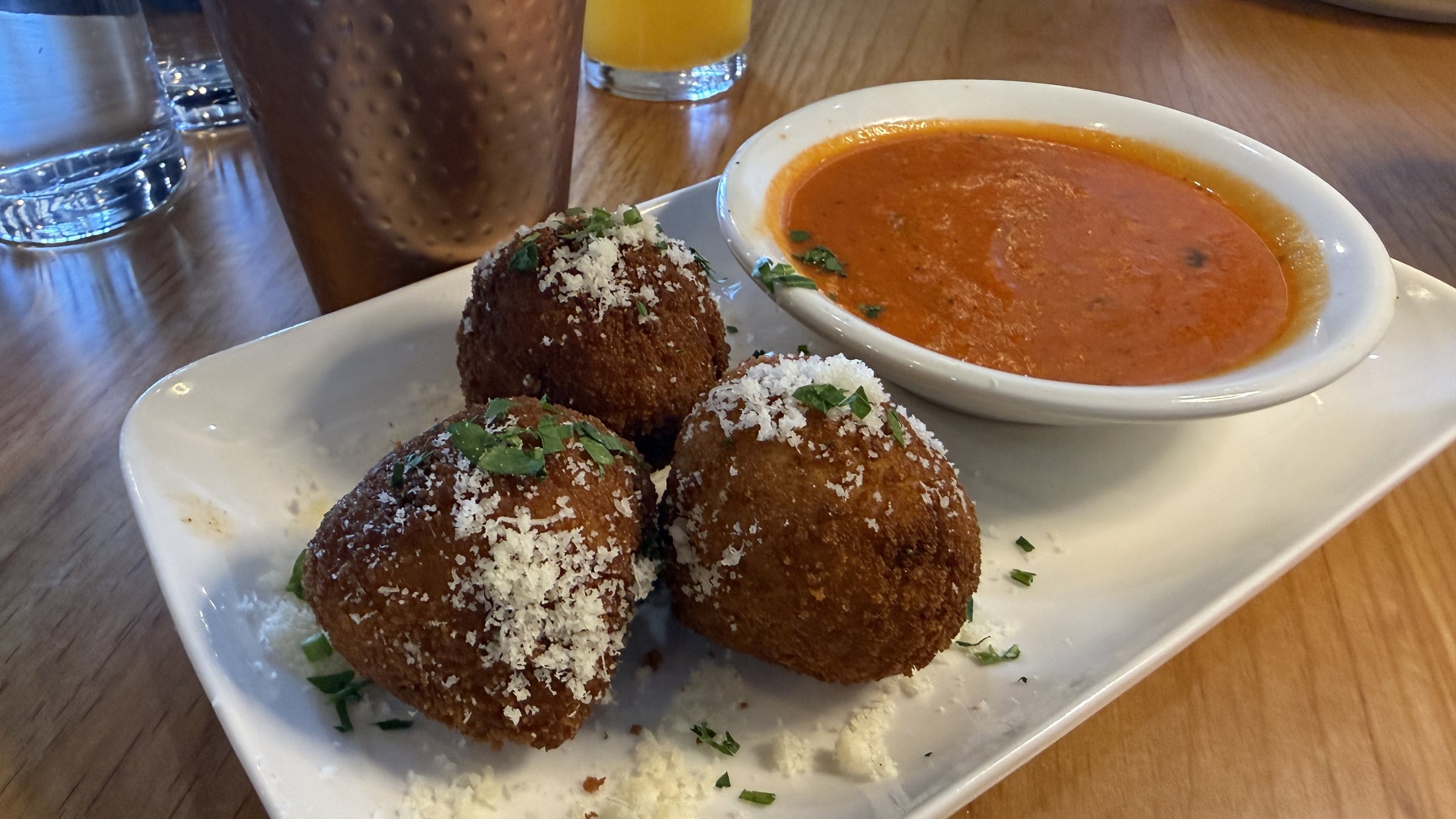 Three fried arancini with red sauce at Pizzeria Amalfi