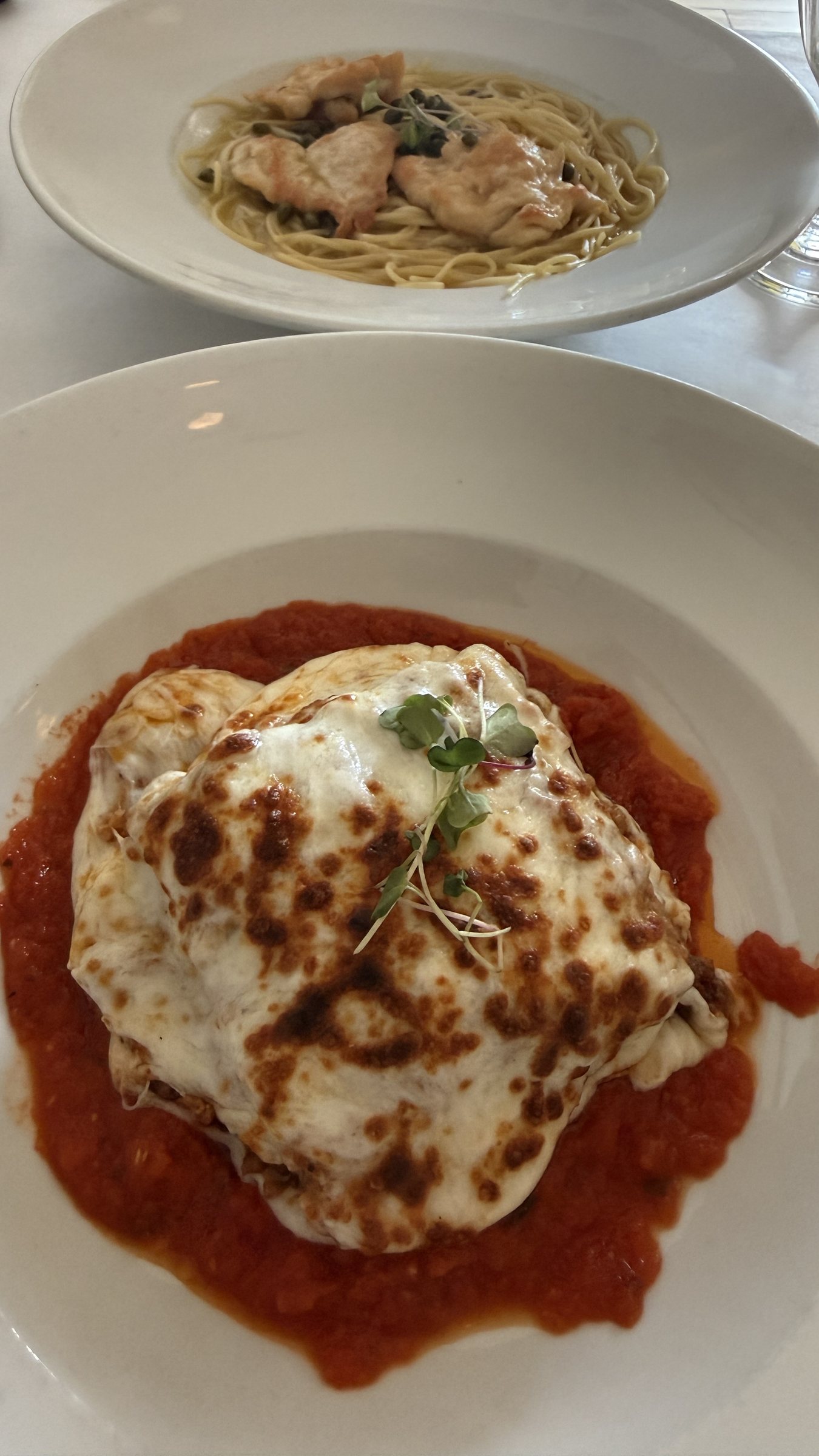Spaghetti with chicken and capers, and a baked dish under melted cheese, at Cafe Grazie