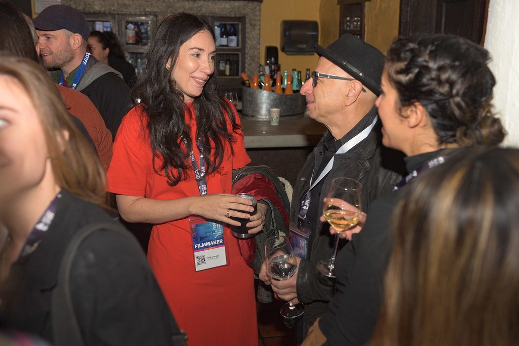 Three people talking at an indoor reception