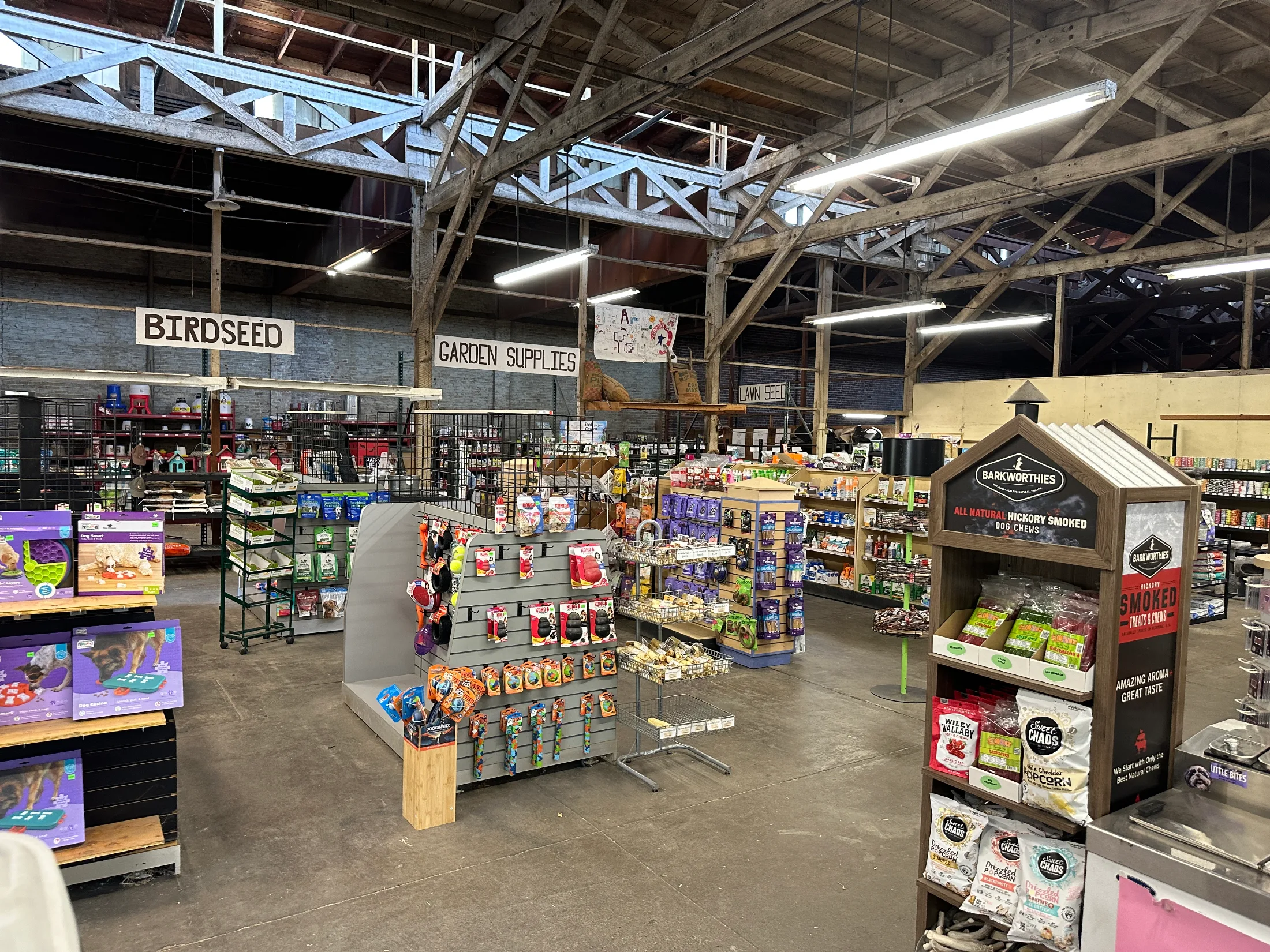 Interior of Northern Star Mills showing birdseed and garden supplies sections under timber-truss ceiling