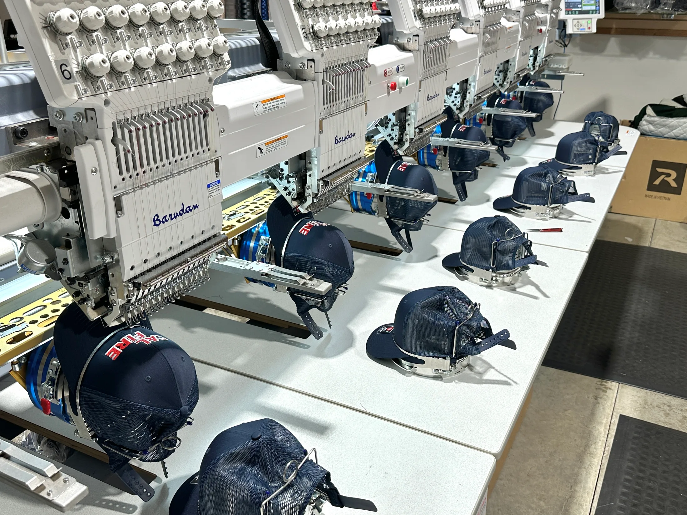 Barudan embroidery machines stitching CAL FIRE hats at Down Range Chico