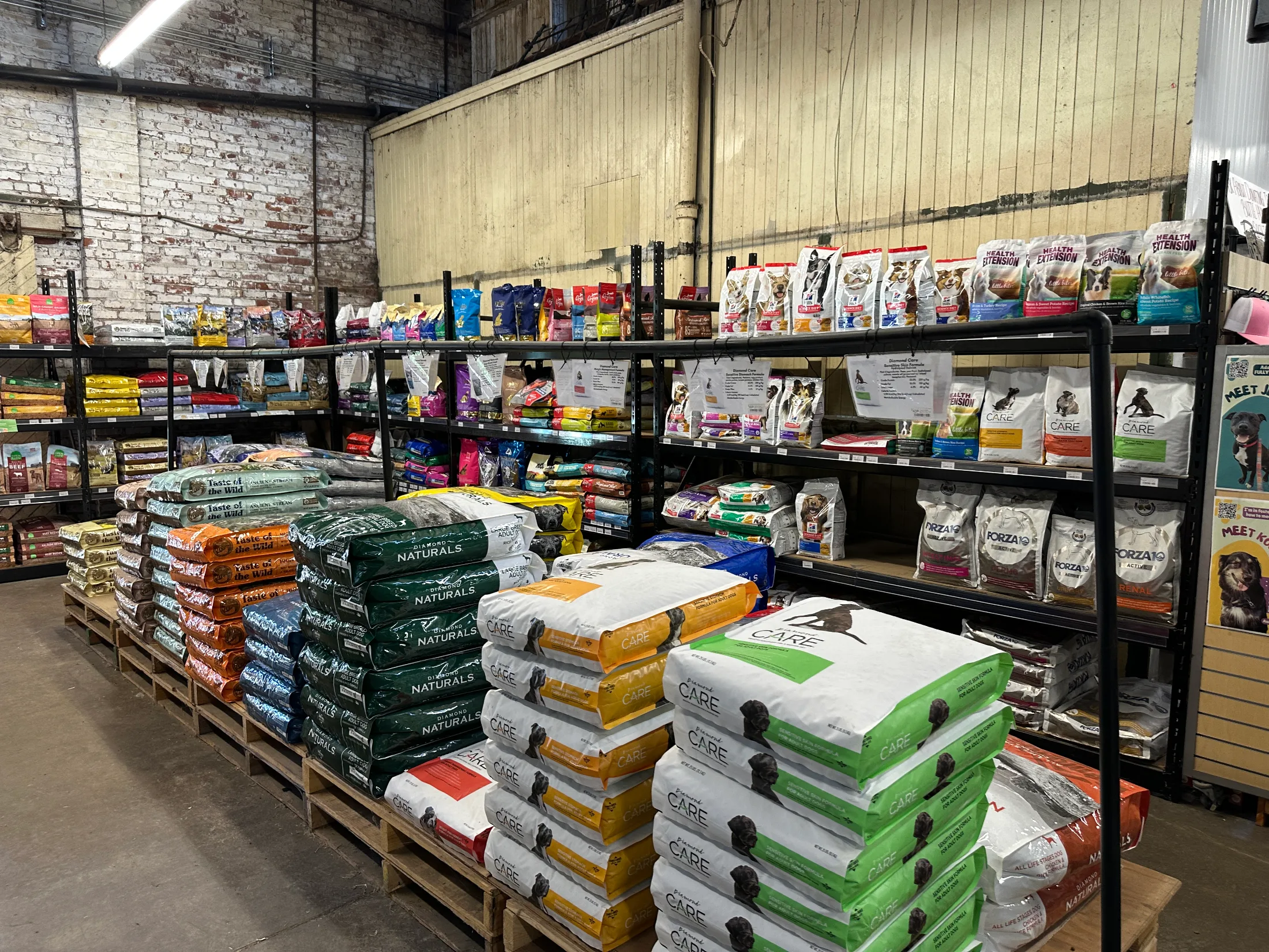 Stacked pallets and shelves of pet food bags including Diamond Naturals and Taste of the Wild