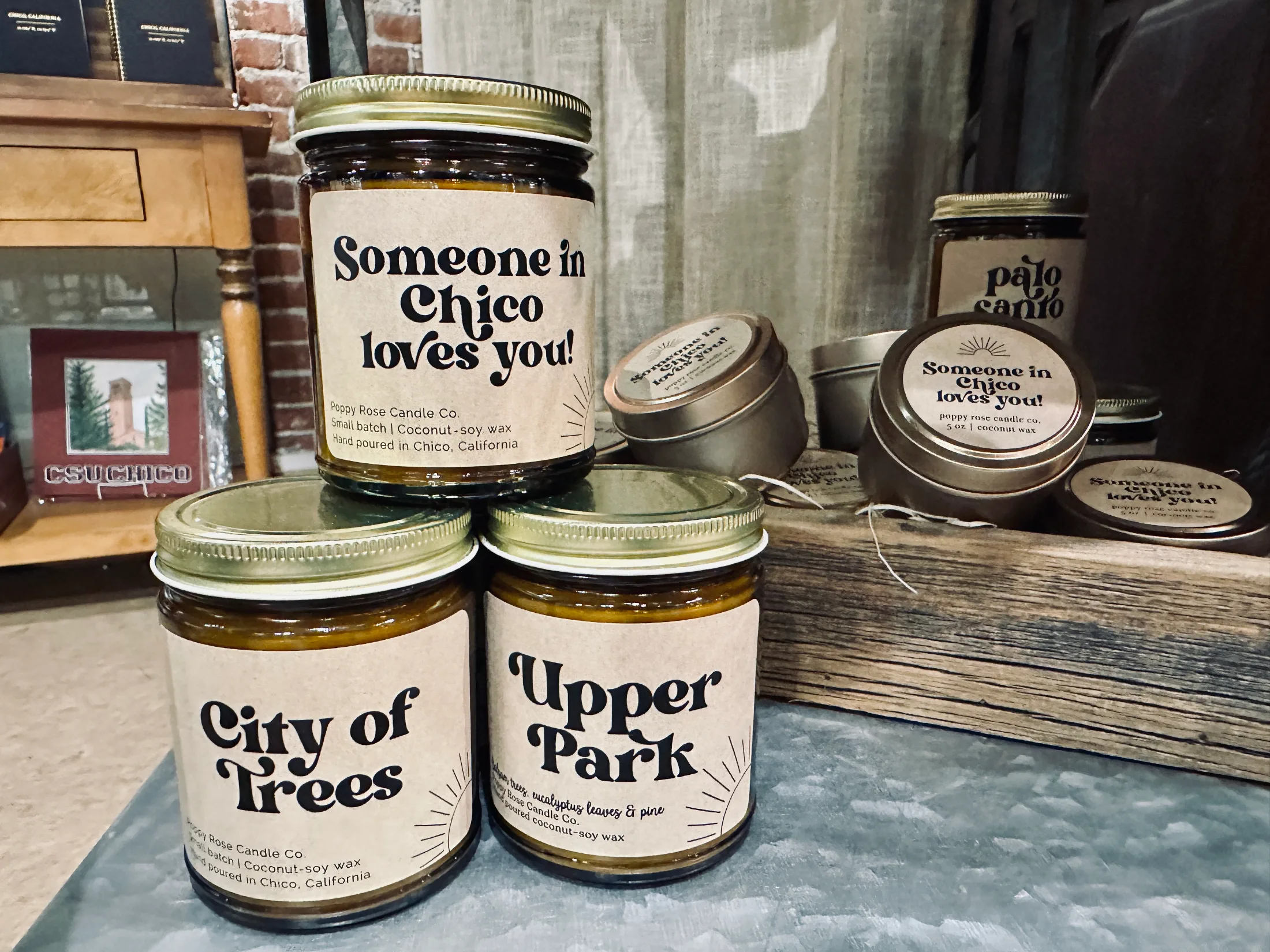 Poppy Rose Candle Co. candles on display at Made in Chico, including scents named City of Trees, Upper Park, and Someone in Chico Loves You, made with coconut-soy wax and hand poured in Chico, California