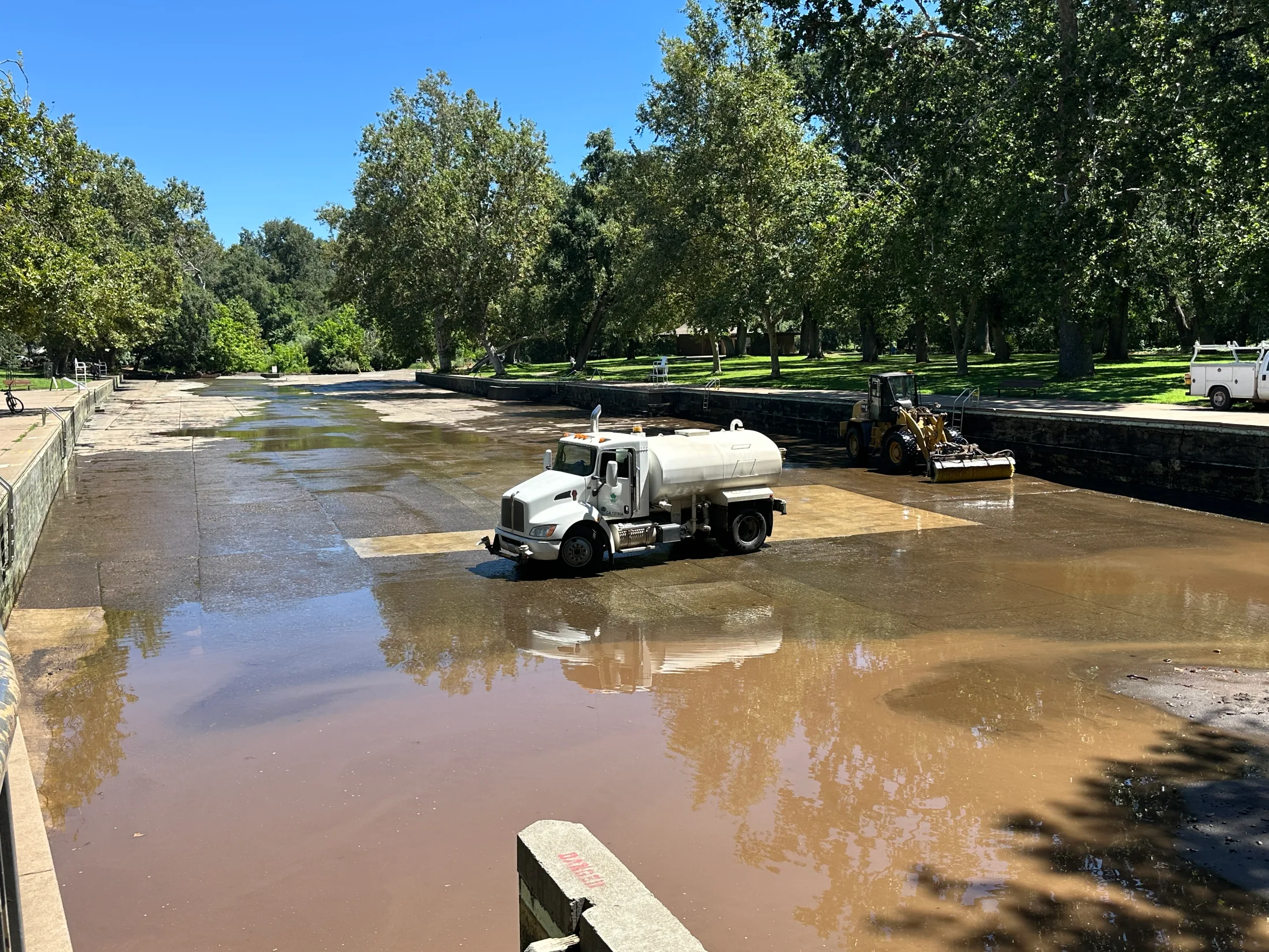 City of Chico water tanker and equipment cleaning the drained One Mile swimming hole during weekly maintenance