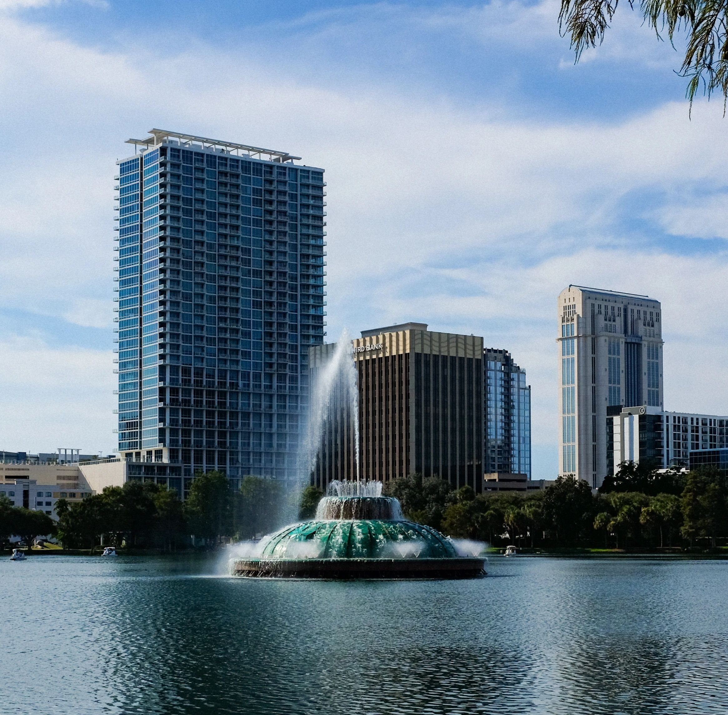 The Lake Eola fountain in Downtown Orlando with glass towers behind it