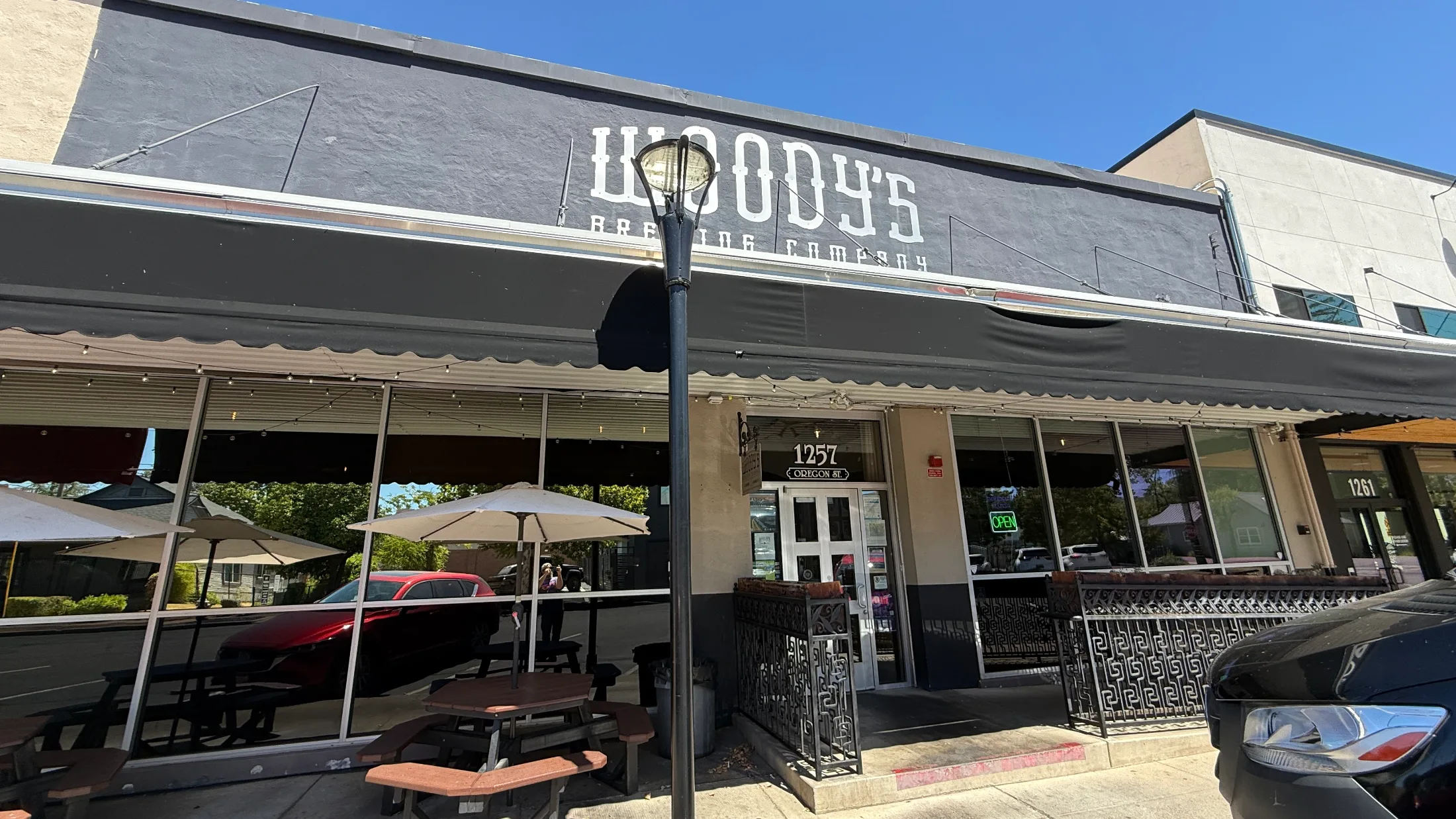 Exterior of Woody's Brewing Company at 1257 Oregon Street in downtown Redding, CA, with covered patio seating out front