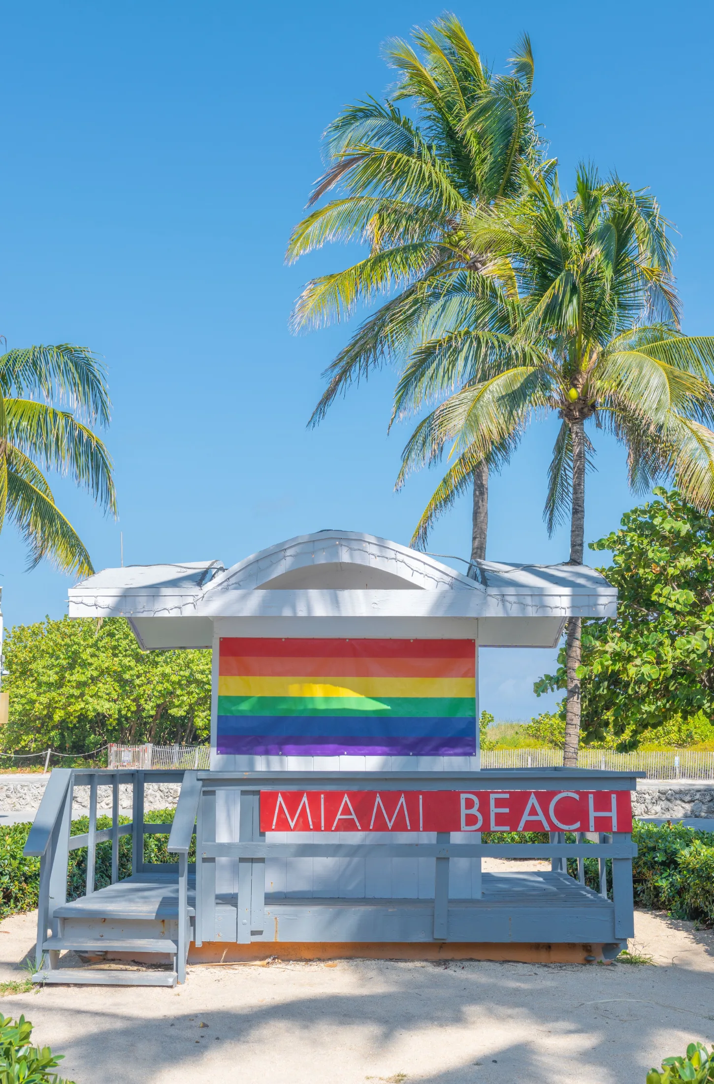 Miami Beach lifeguard stand displaying a rainbow pride flag under a clear blue sky