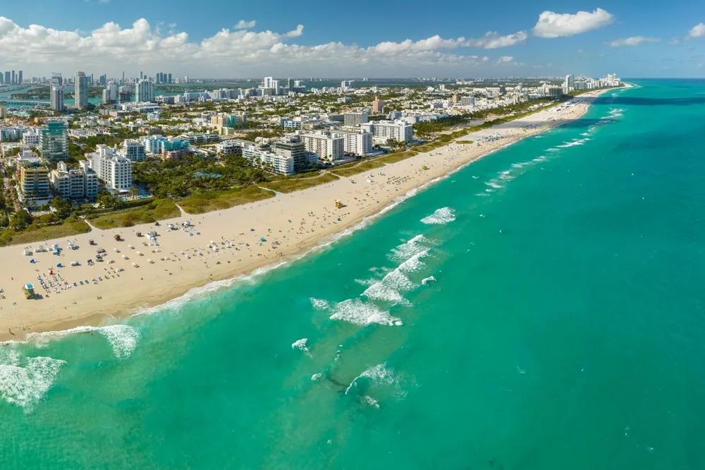 Aerial view of Miami Beach shoreline with turquoise Atlantic water and a wide stretch of white sand