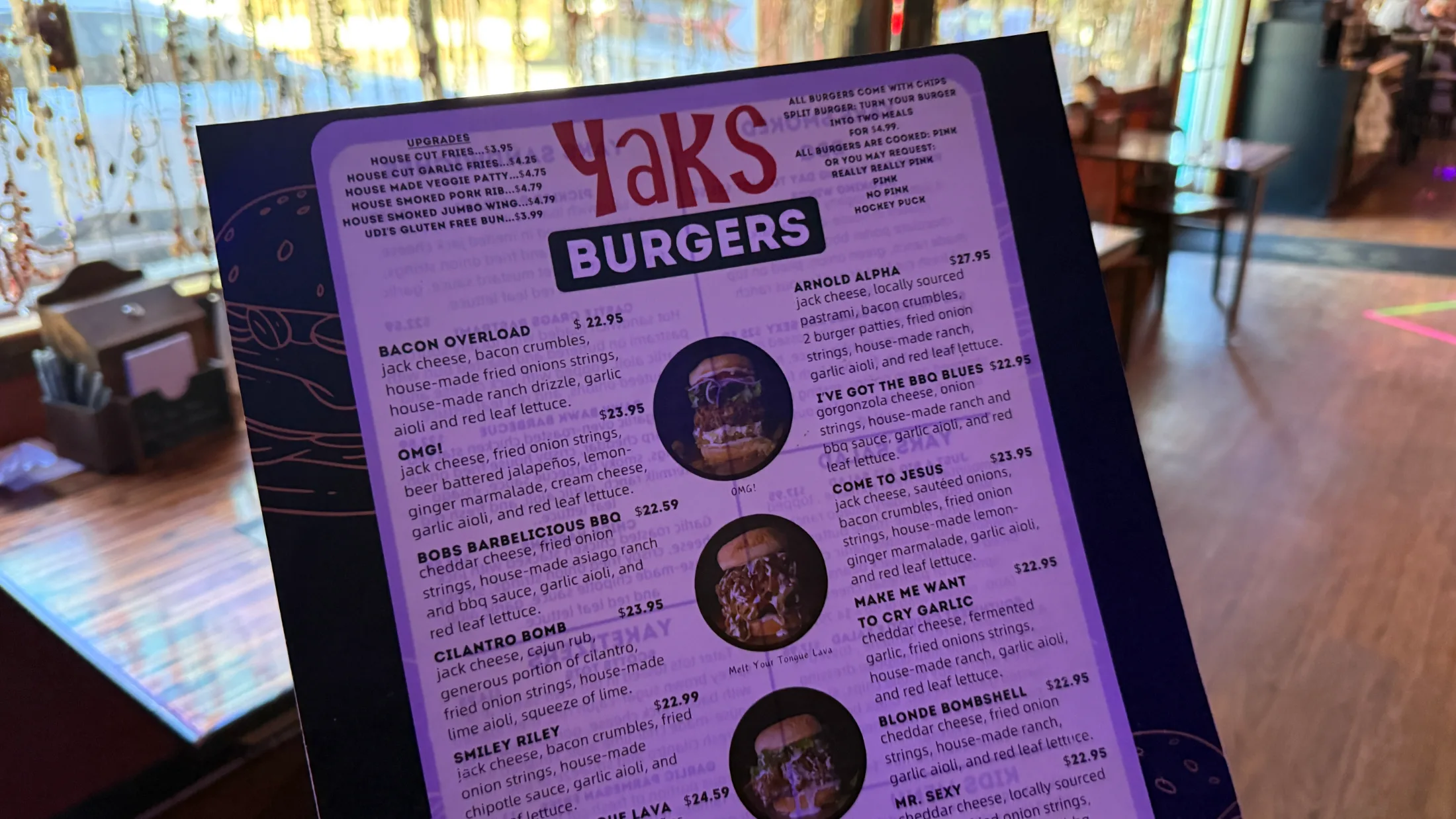 The Yaks on the 5 burger menu showing named burgers including Arnold Alpha, OMG!, Bob's Barbelicious BBQ, Cilantro Bomb, and more