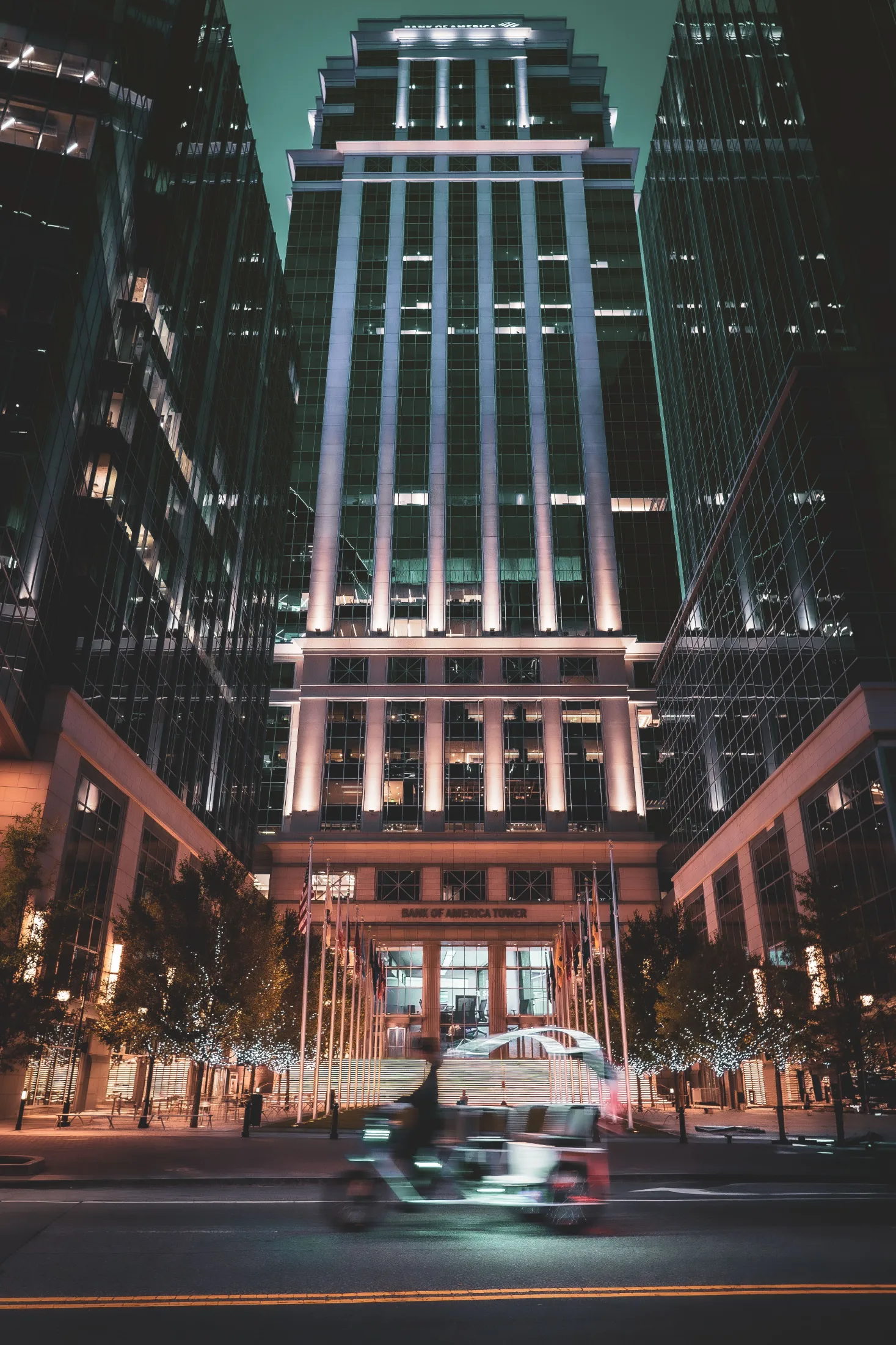 Bank of America Tower in Uptown Charlotte glowing at night, traffic blurred in the foreground