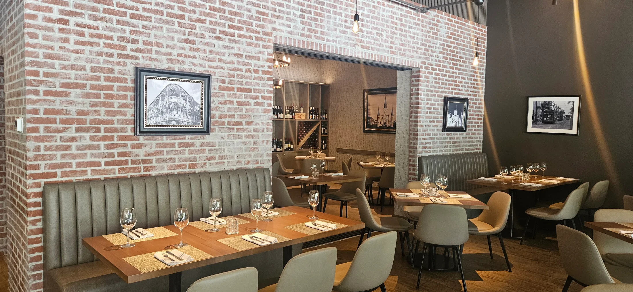 Dining room interior at Schilleci's New Orleans Kitchen with exposed brick walls and French Quarter photography