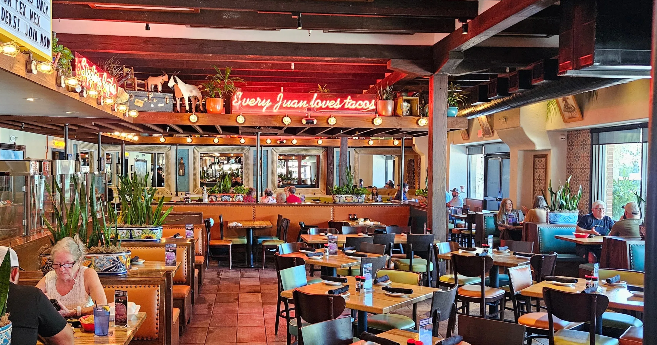 Dining room at Gringo's Tex-Mex with neon Every Juan loves tacos sign