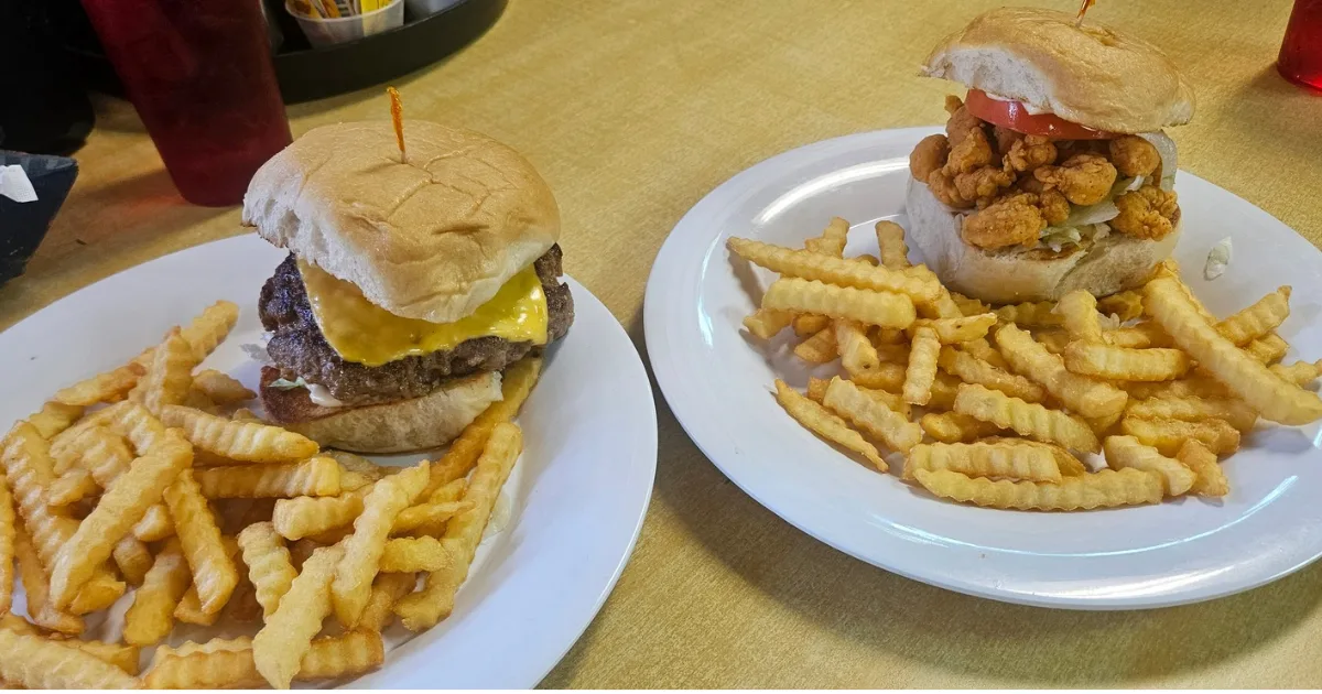 Creole cheeseburger and fried crawfish sandwich side by side at Crazy 'Bout Crawfish