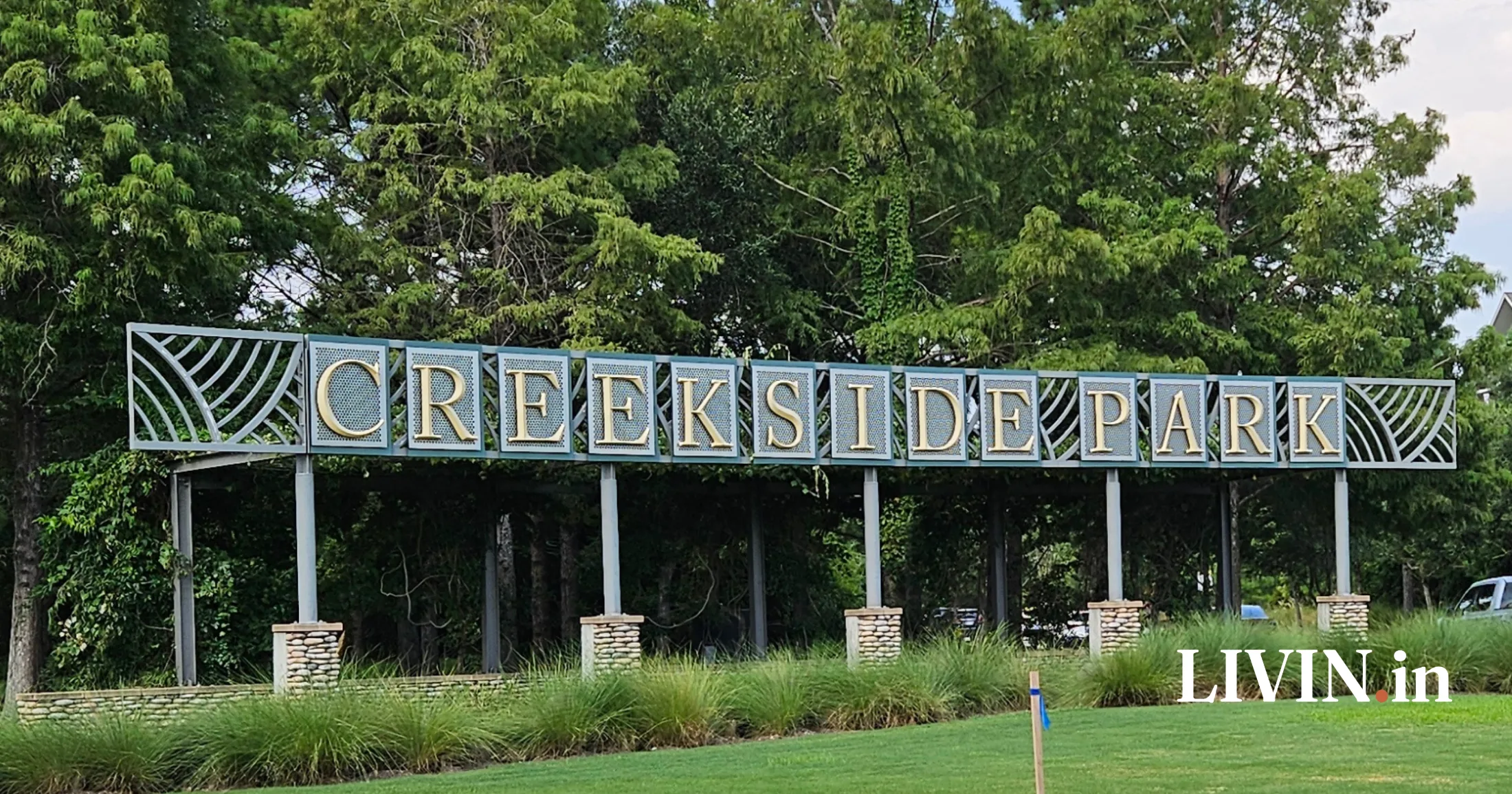 Creekside Park entrance sign with gold lettering on teal panels, The Woodlands, Texas