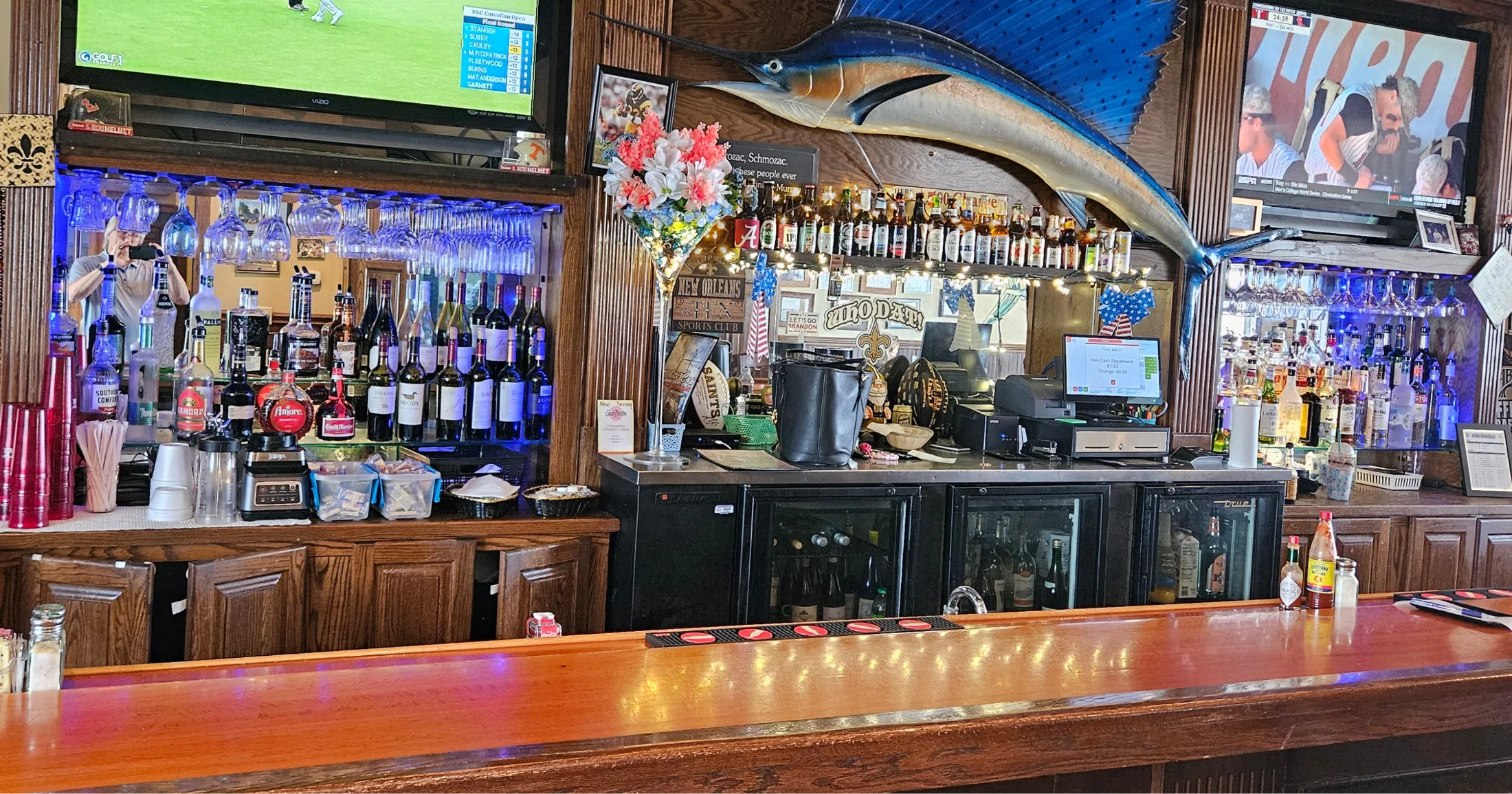 Full bar at White Cap with a mounted marlin above the counter and sports on TV
