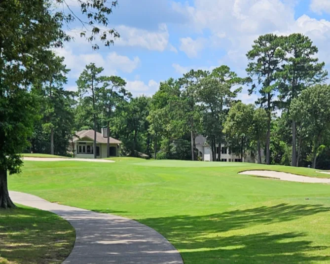 Golf course fairway with sand traps and pine trees in The Woodlands
