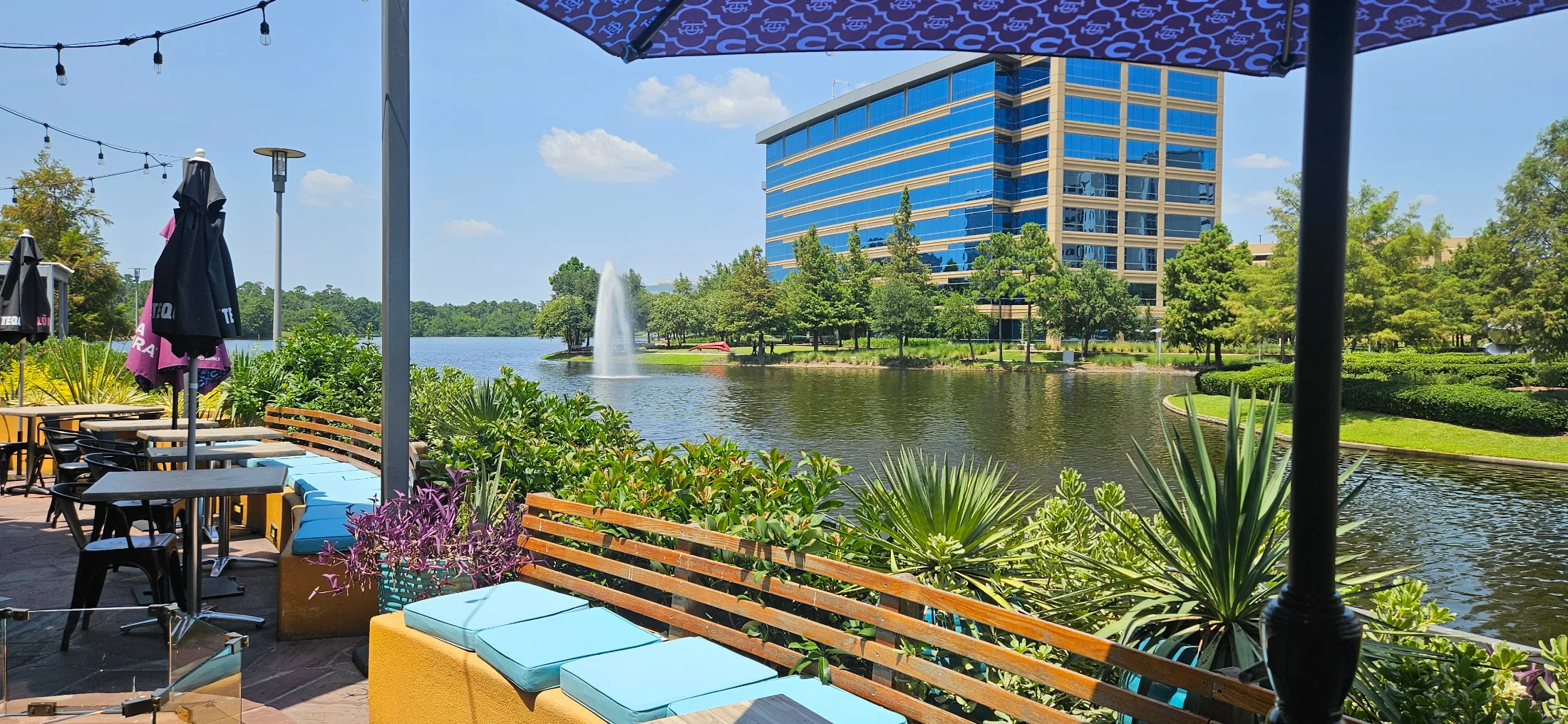 Patio view from Escalante's Hughes Landing looking out over Lake Woodlands with fountain and office buildings