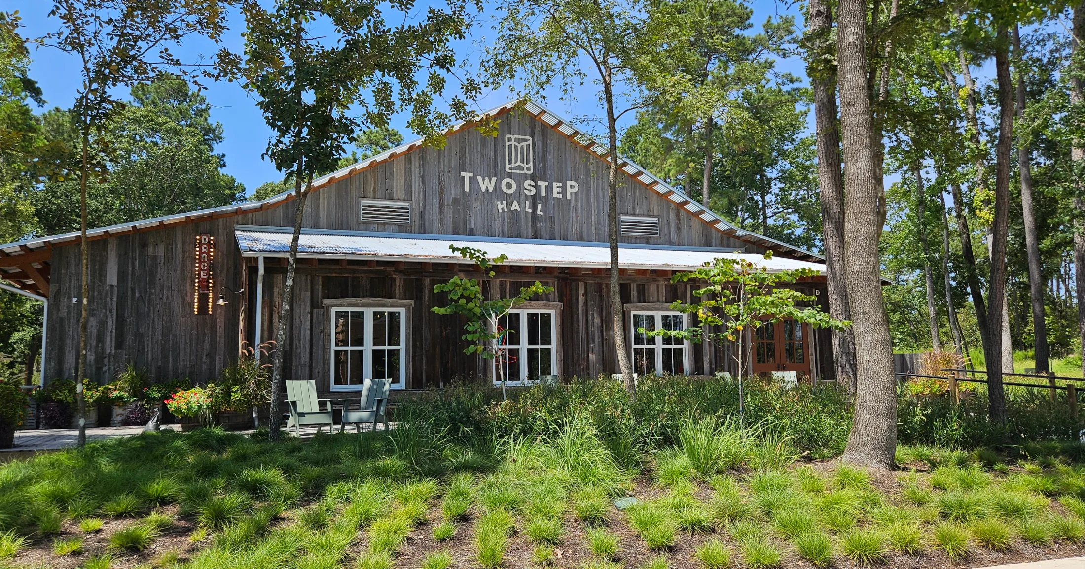 Two Step Hall, a weathered wood dance hall with a metal roof and neon Dance sign