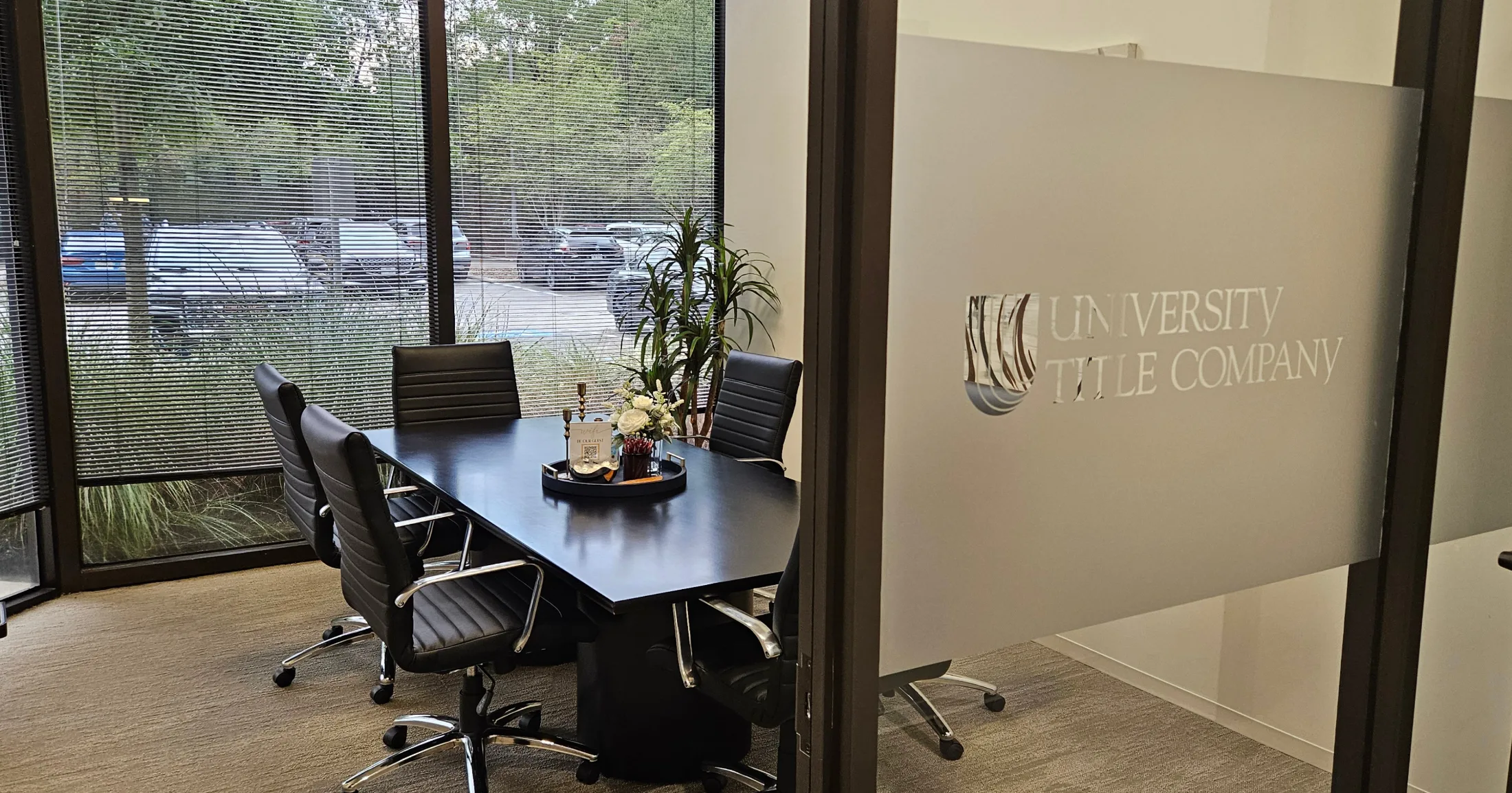 University Title Company conference room with floor-to-ceiling windows and branded glass partition