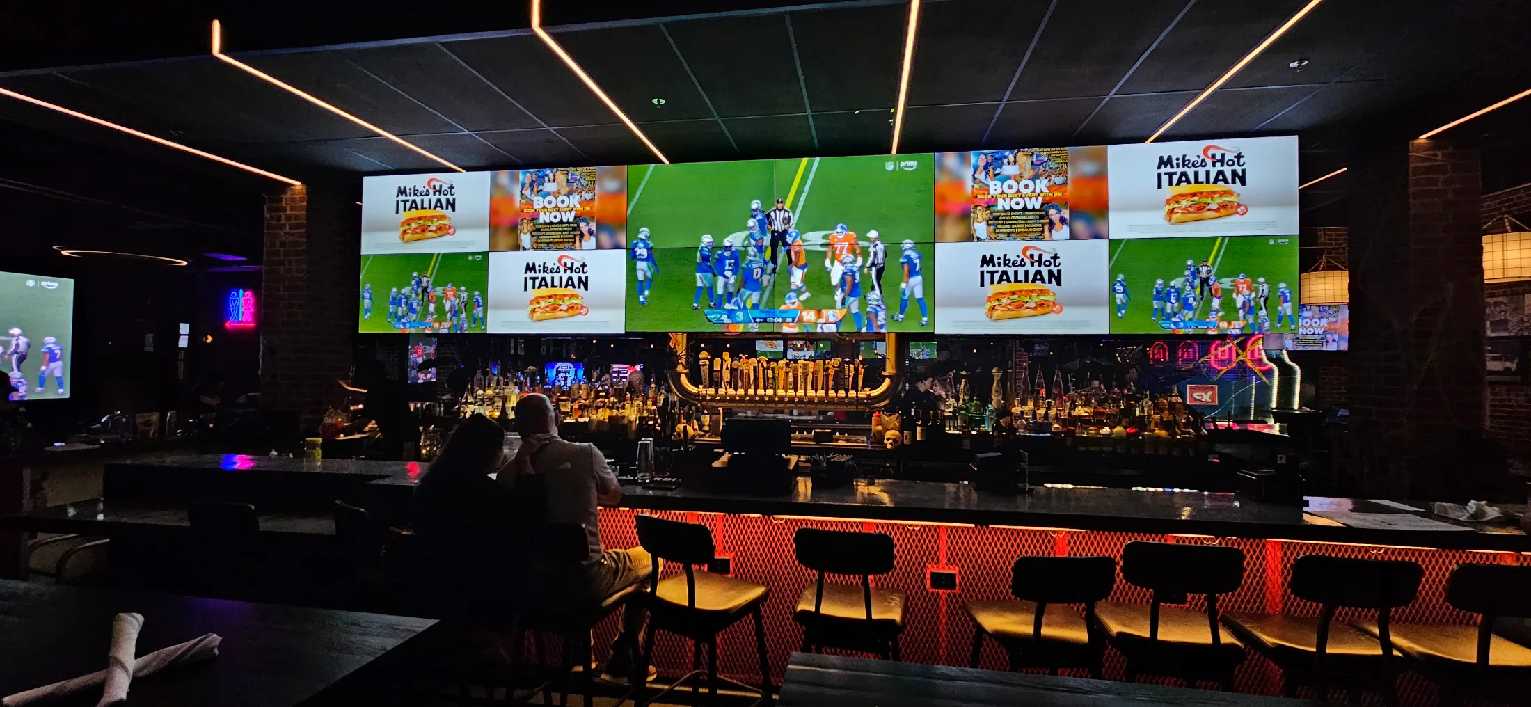 Full video wall above the main bar at Ale and Ivy showing the NFL game