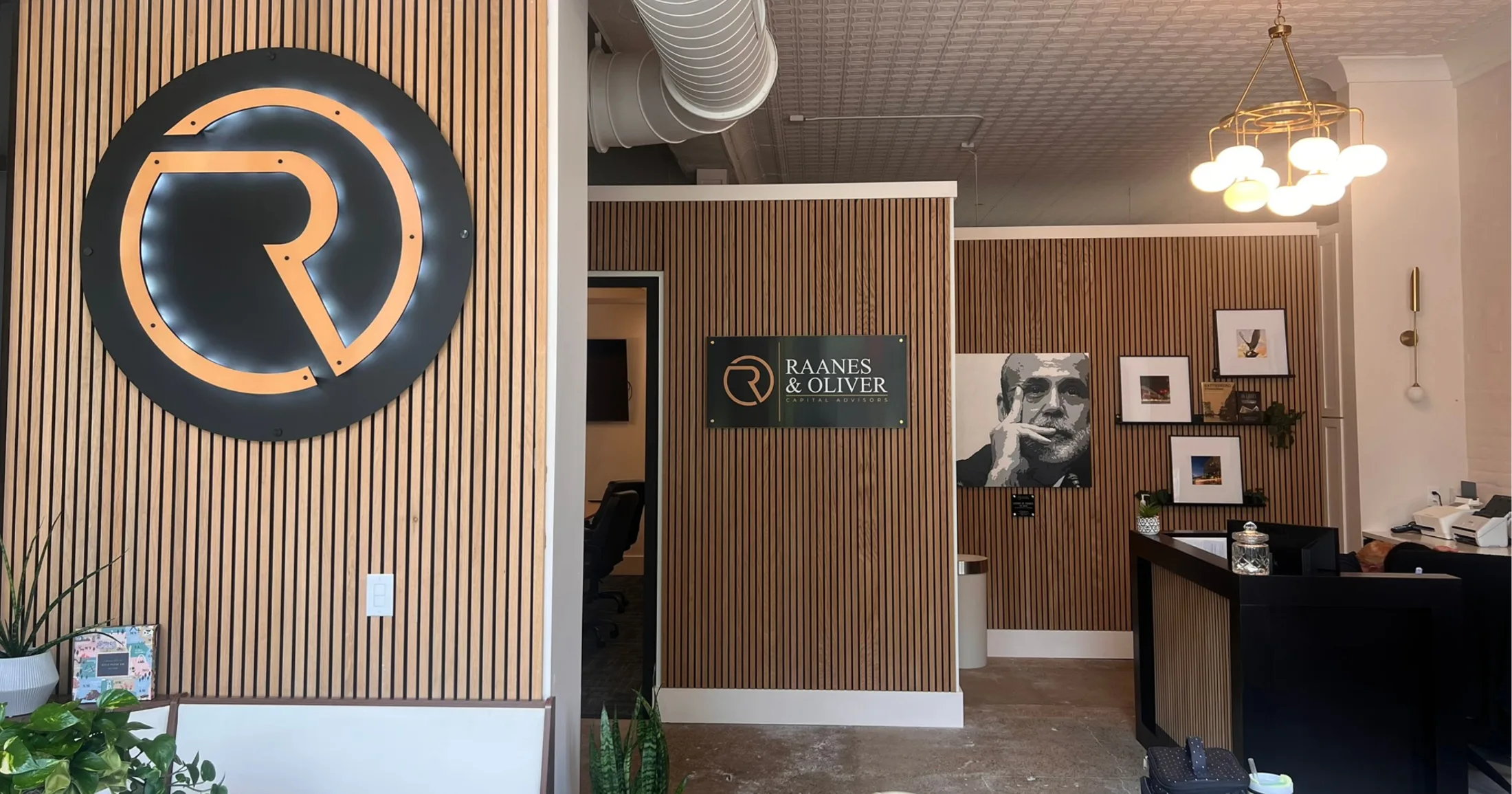 Raanes & Oliver Capital Advisors lobby with branded signage on wood-slat wall