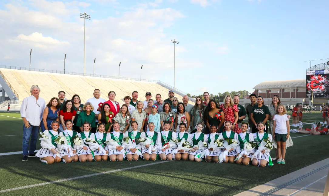 Current Highsteppers in uniform pose on the field with their families at Woodforest Bank Stadium