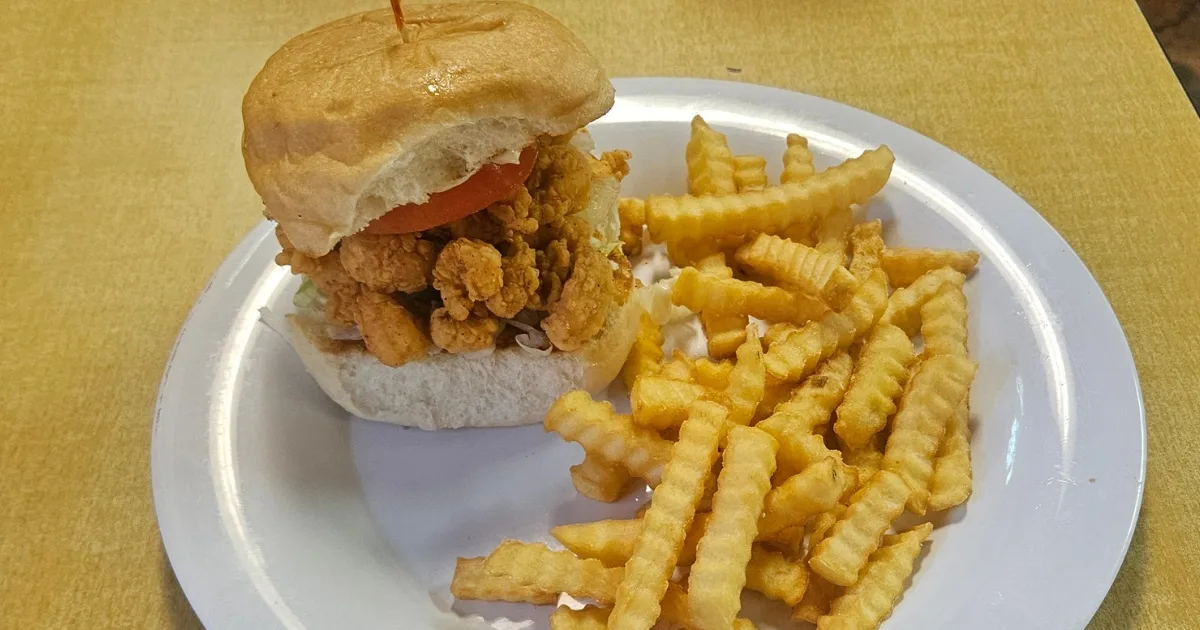 Fried crawfish sandwich piled high with crinkle fries at Crazy 'Bout Crawfish