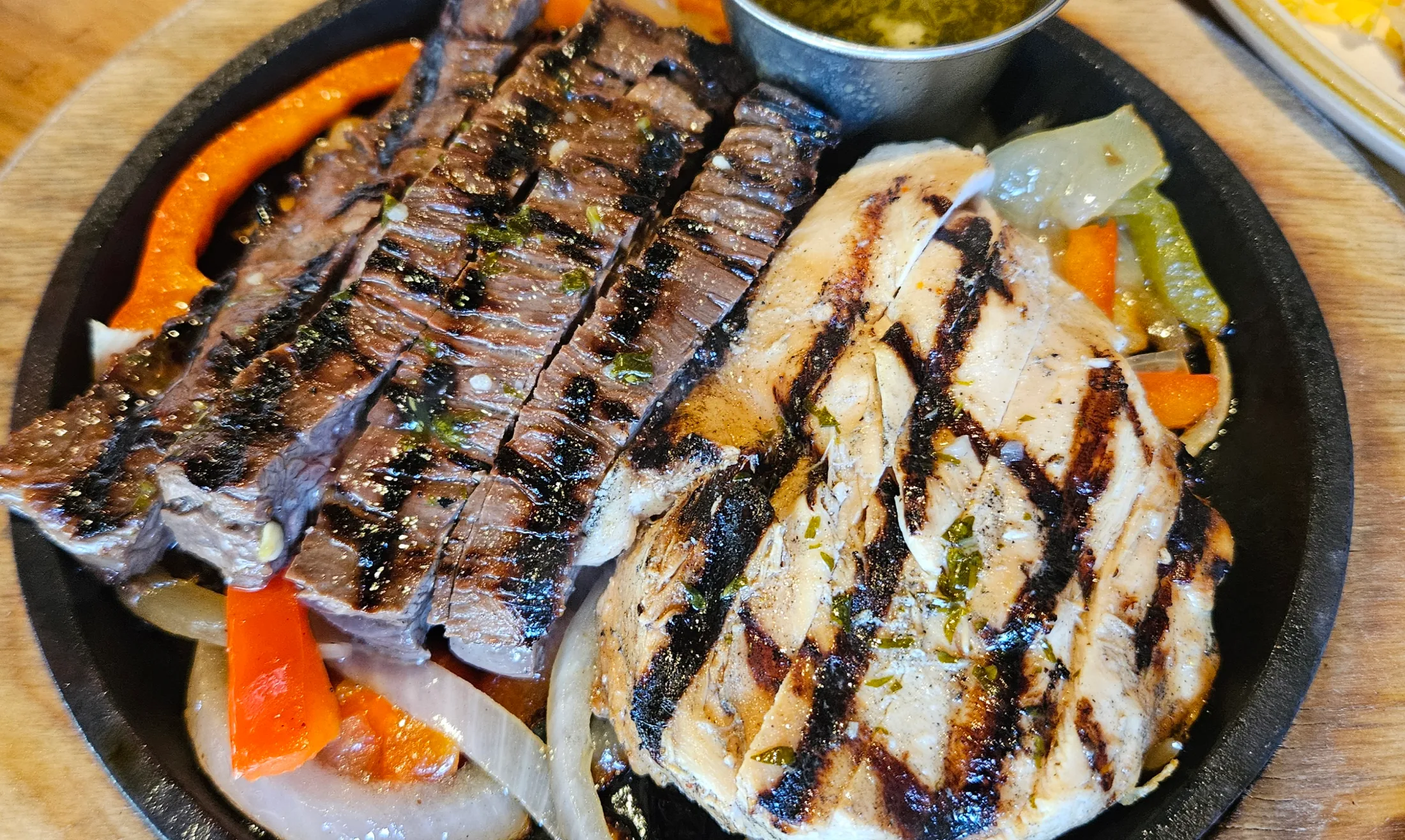 Close-up of the beef and chicken fajitas on a cast iron skillet at Escalante's Hughes Landing