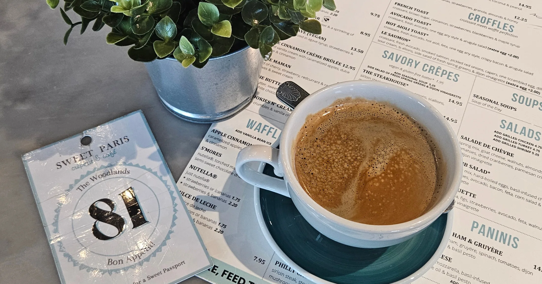 Sweet Paris order number card and café coffee cup on table next to menu