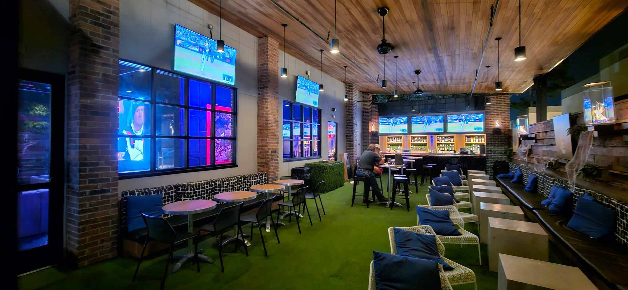 Ale and Ivy illuminated sign on a brick wall with booth seating below