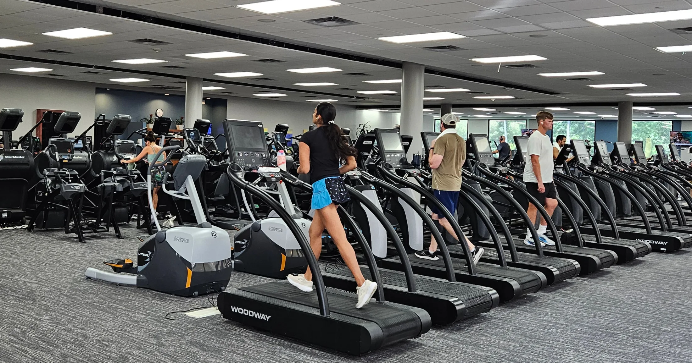 Members running on Woodway treadmills on the expansive Villa Sport fitness floor