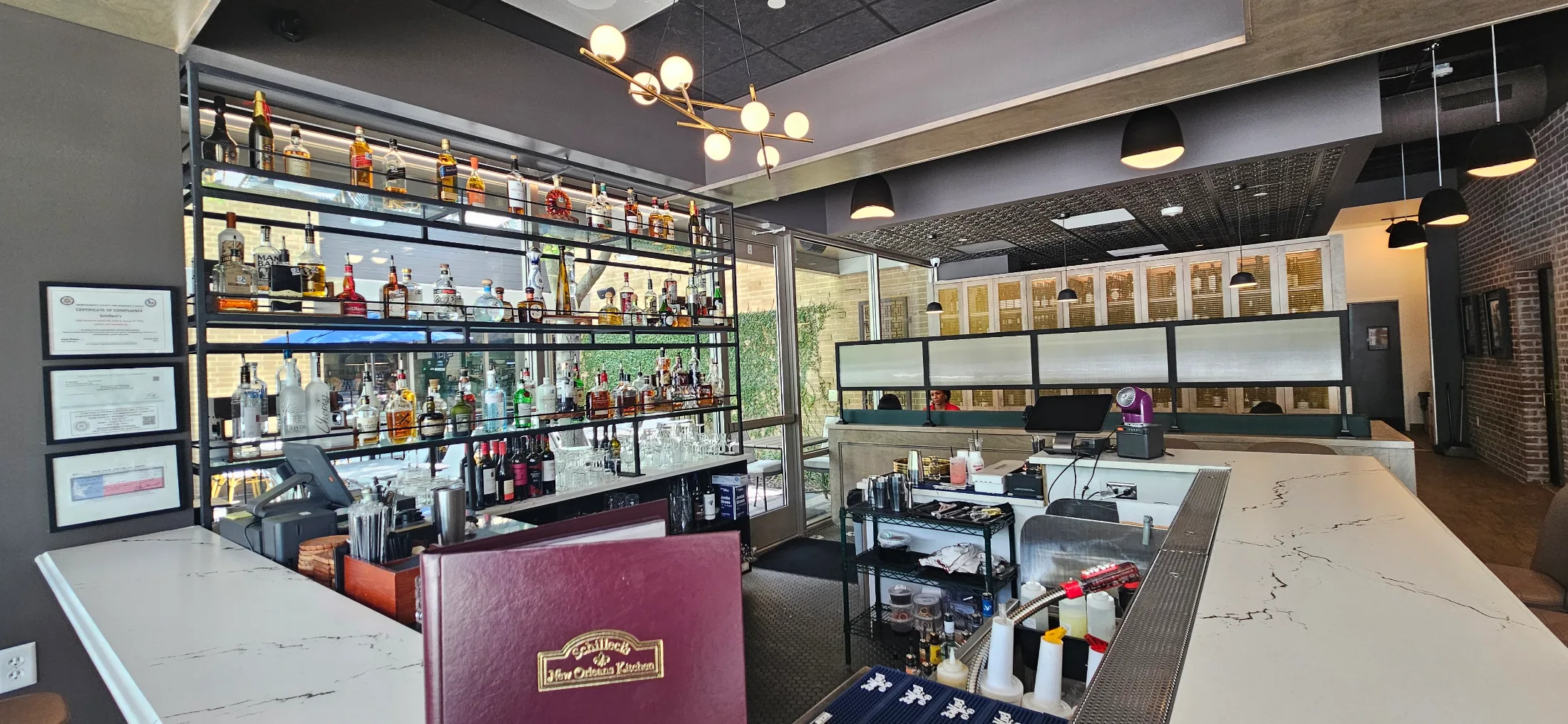 Bar area at Schilleci's New Orleans Kitchen with full liquor display and marble countertop