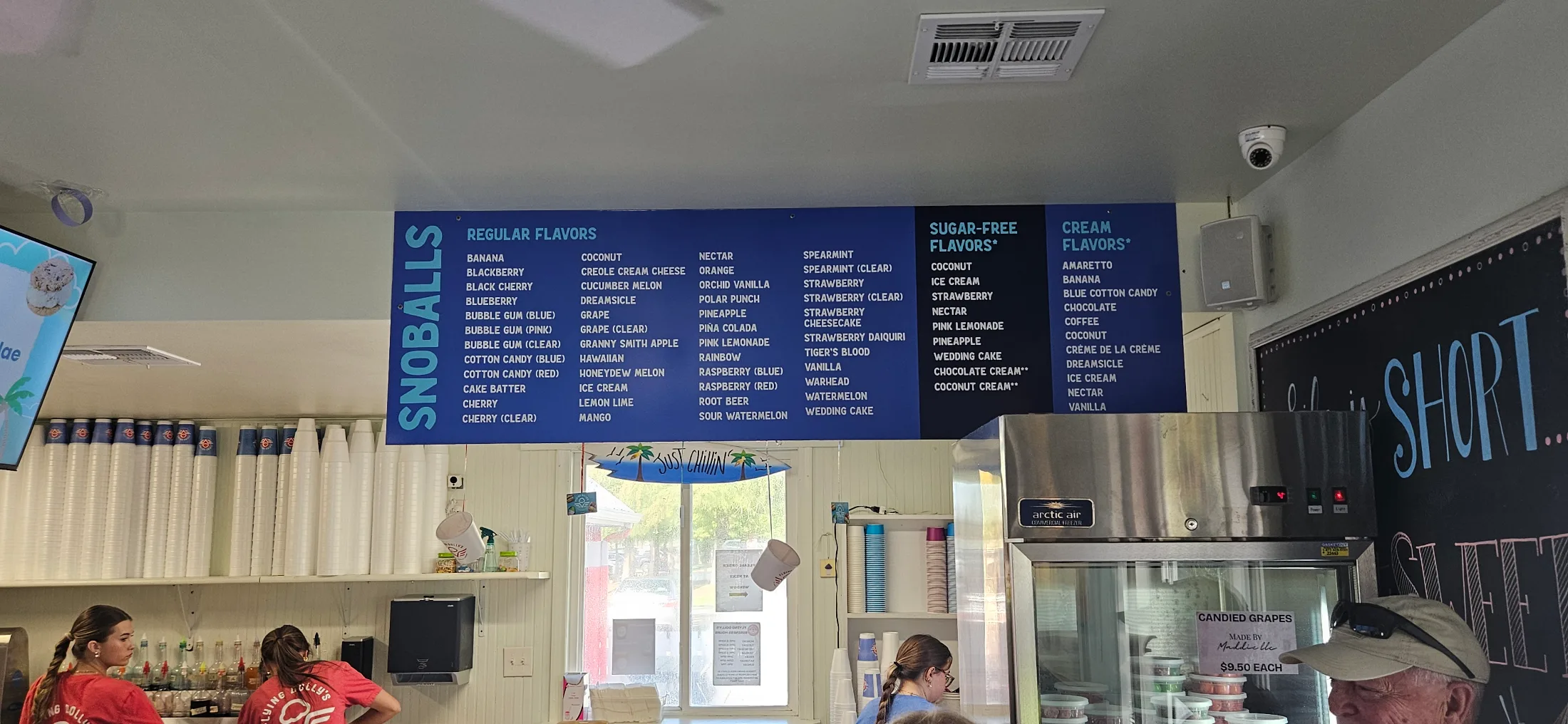 Snoball flavor menu board inside Flying Dolly's showing dozens of regular, sugar-free, and cream flavor options
