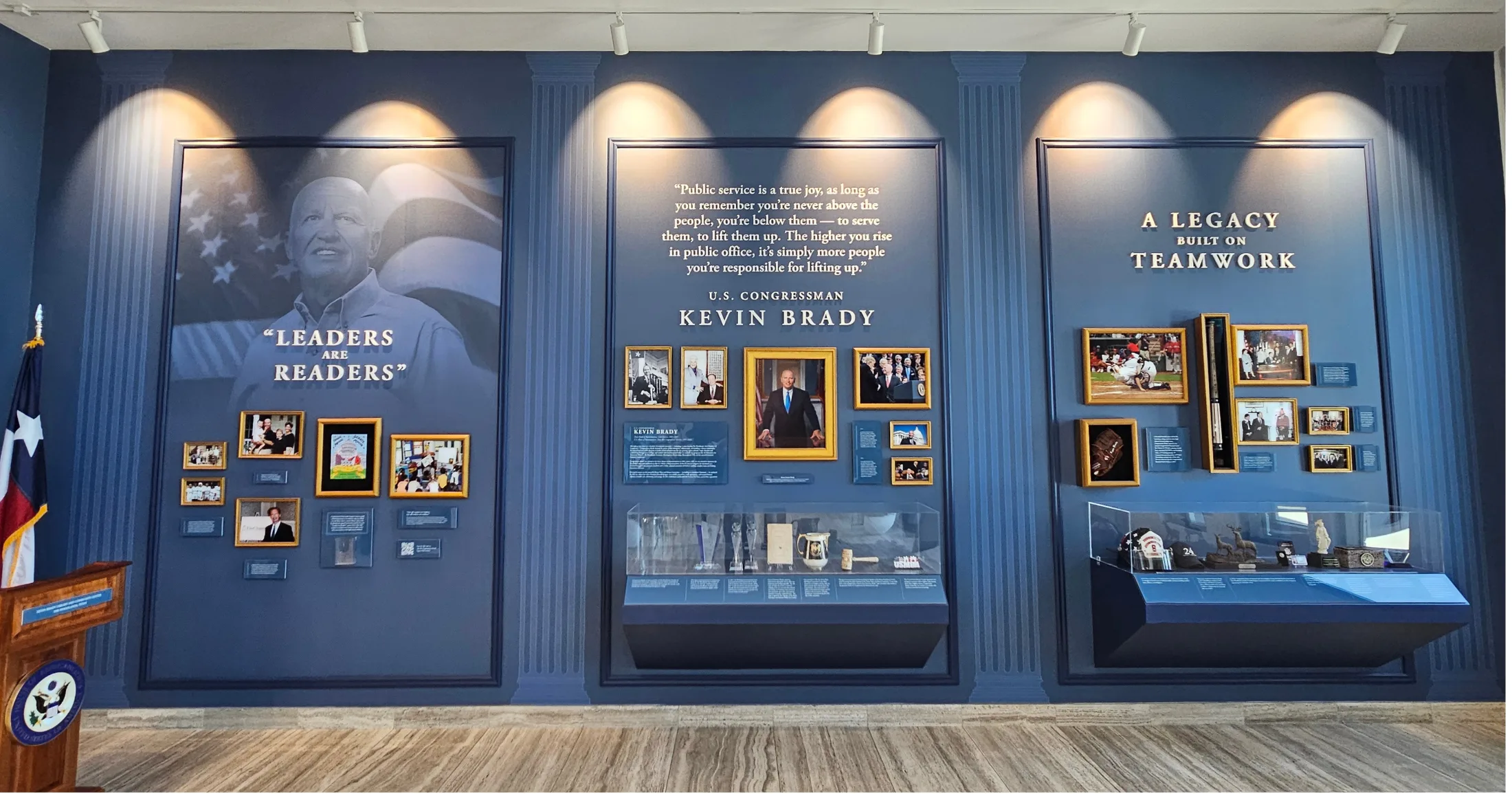 Kevin Brady memorial gallery inside the library featuring framed photos, display cases, and a quote about public service
