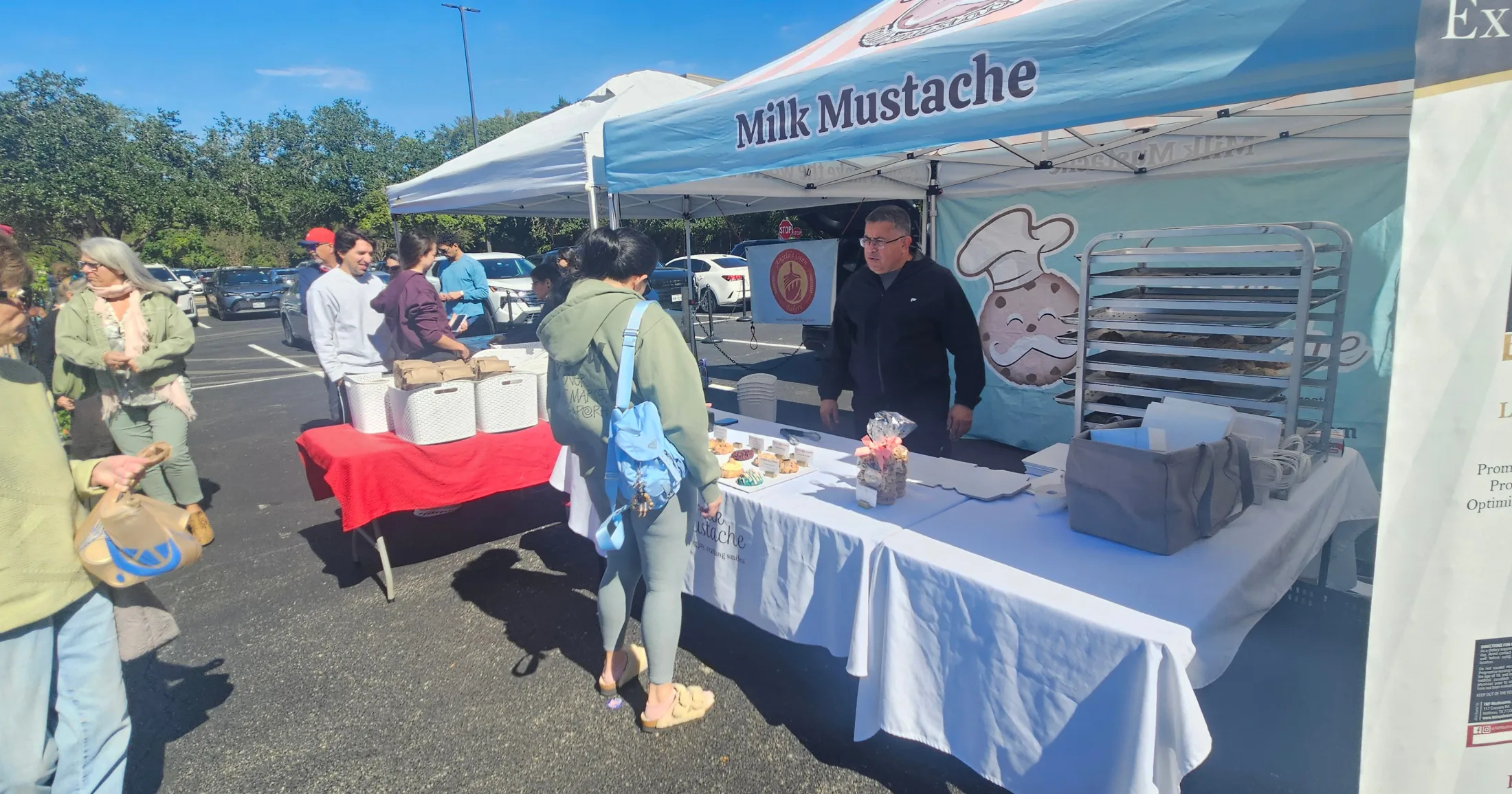 Milk Mustache bakery booth with customers browsing at the Grogan's Mill Farmers Market