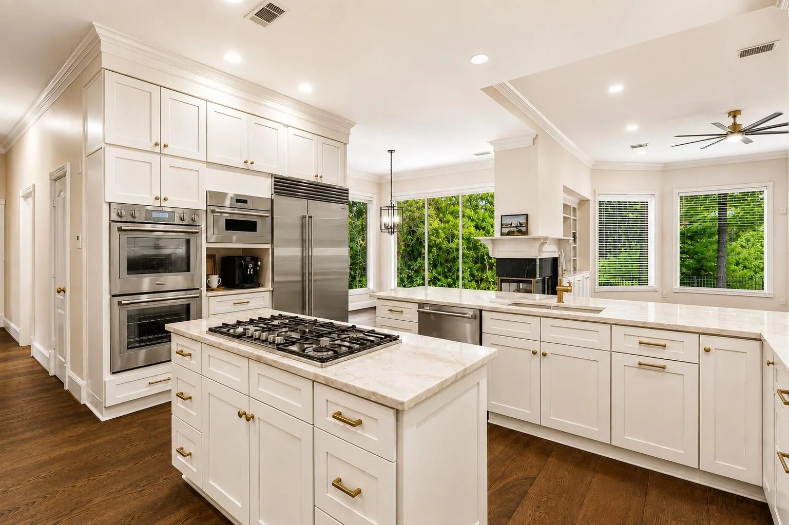 Updated kitchen at 7 Pastoral Pond Circle with white shaker cabinets, marble counters, brass hardware, and stainless appliances