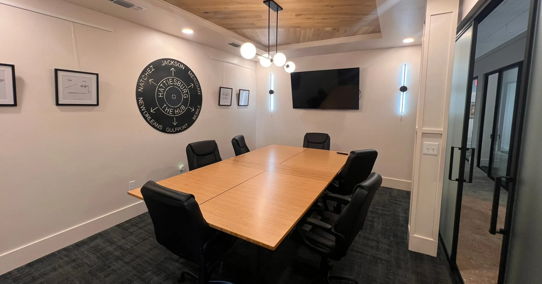 ROCA conference room with a Hattiesburg-as-the-hub compass art piece on the wall