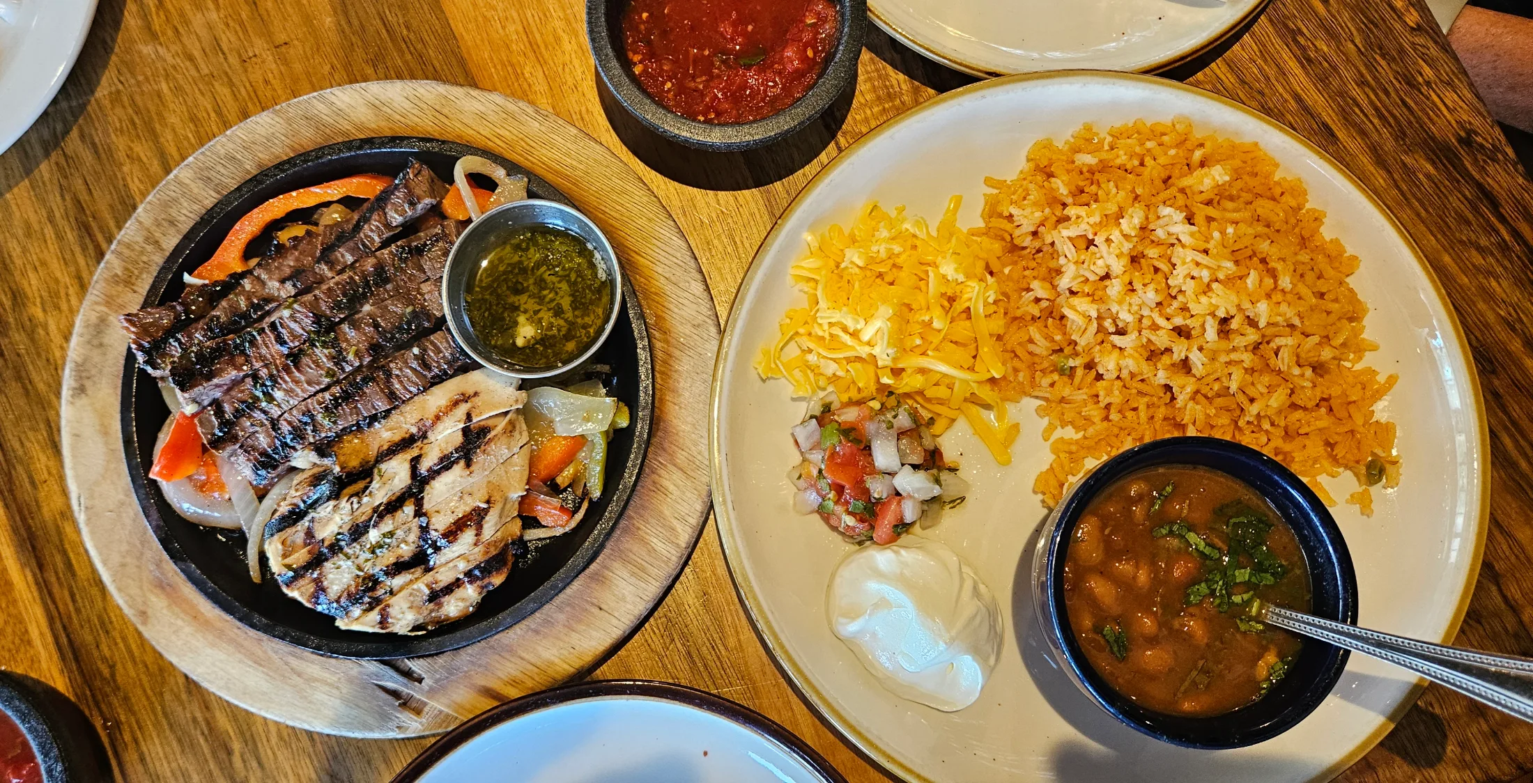 Combination beef and chicken fajitas with rice, beans, pico, and sour cream at Escalante's