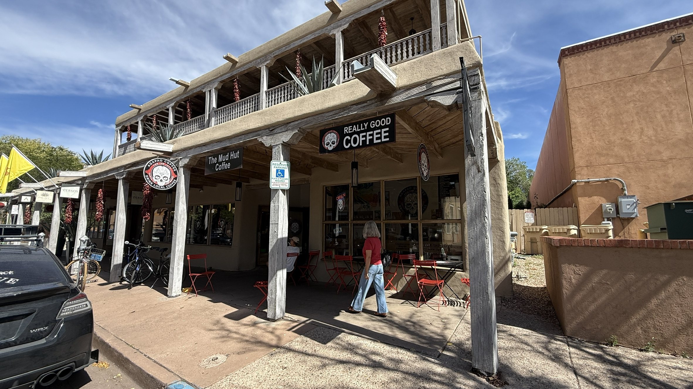 A wooden portal with a black sign reading Really Good Coffee and a hanging sign reading The Mud Hut Coffee