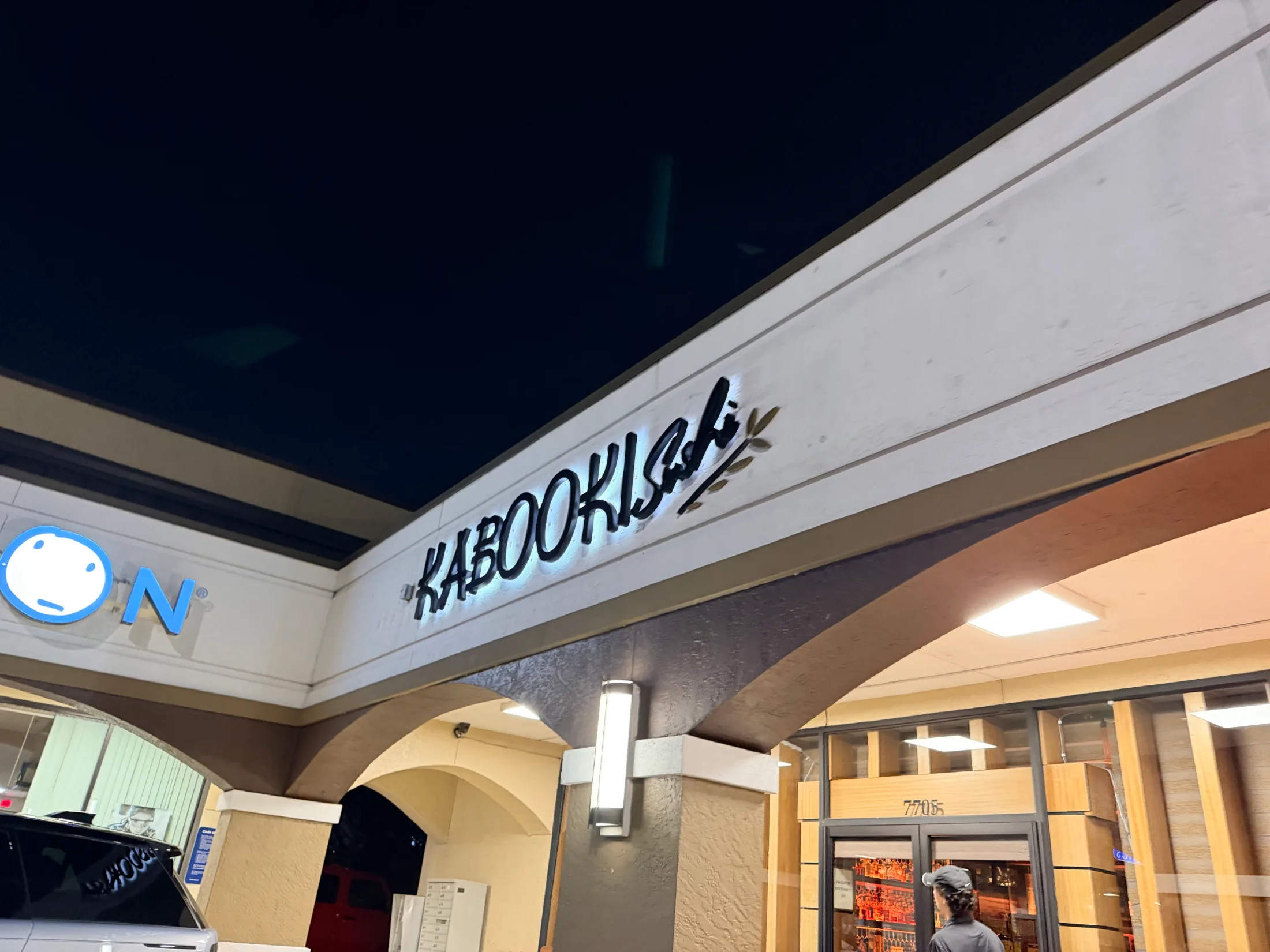 Kabooki Sushi exterior sign lit at night above the entrance at 7705 Turkey Lake Road, Orlando