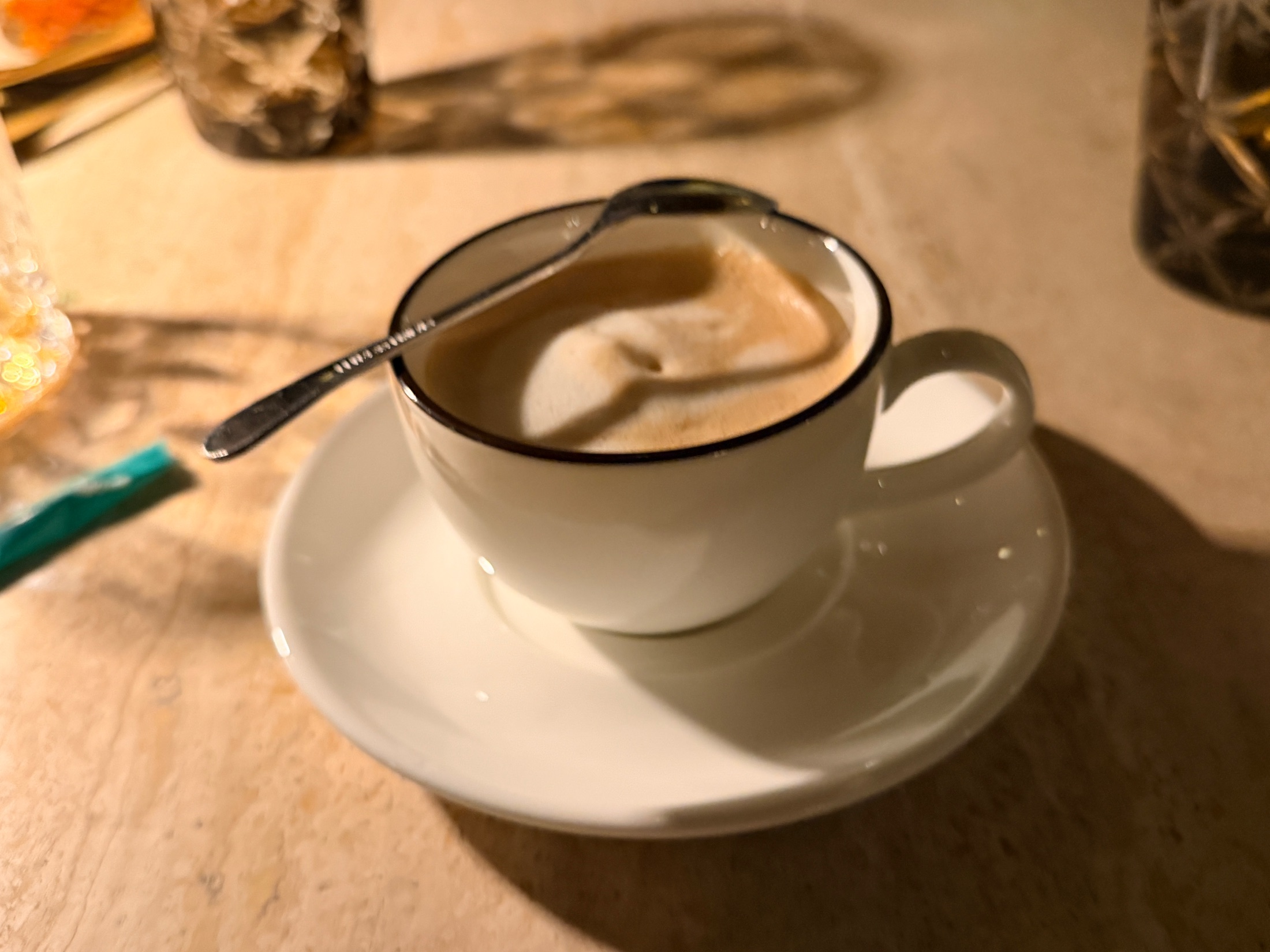 Coffee service at Salt and the Cellar in a white cup with a black rim on a saucer